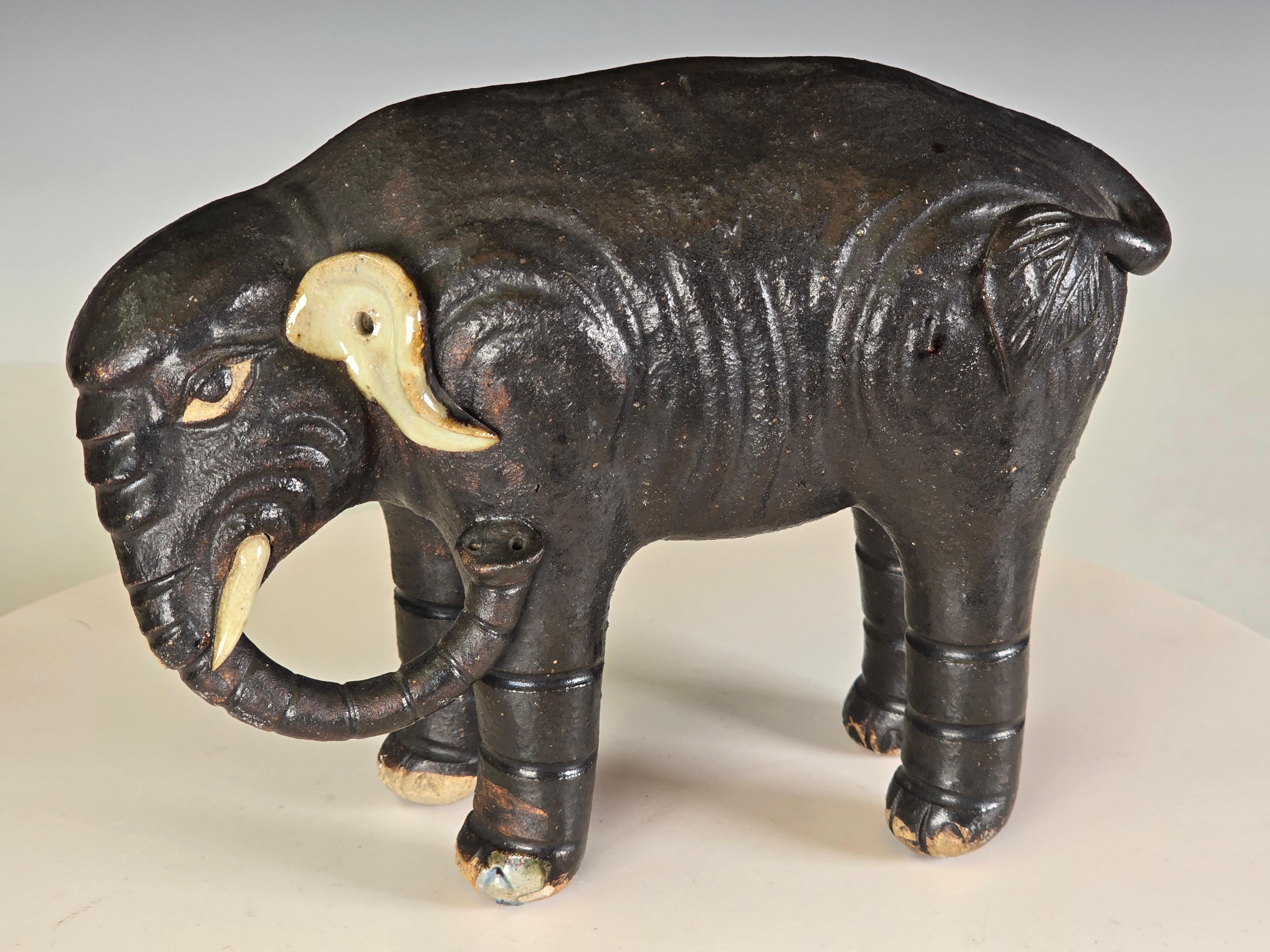 Escultura de elefante de cerámica Shiwan o Shekwan, de mediados o finales del siglo XIX, con el cuerpo realizado en óxido de hierro y las orejas y los ojos esmaltados, hermoso aspecto escultórico de cómo el artista plasmó y estilizó los rasgos del