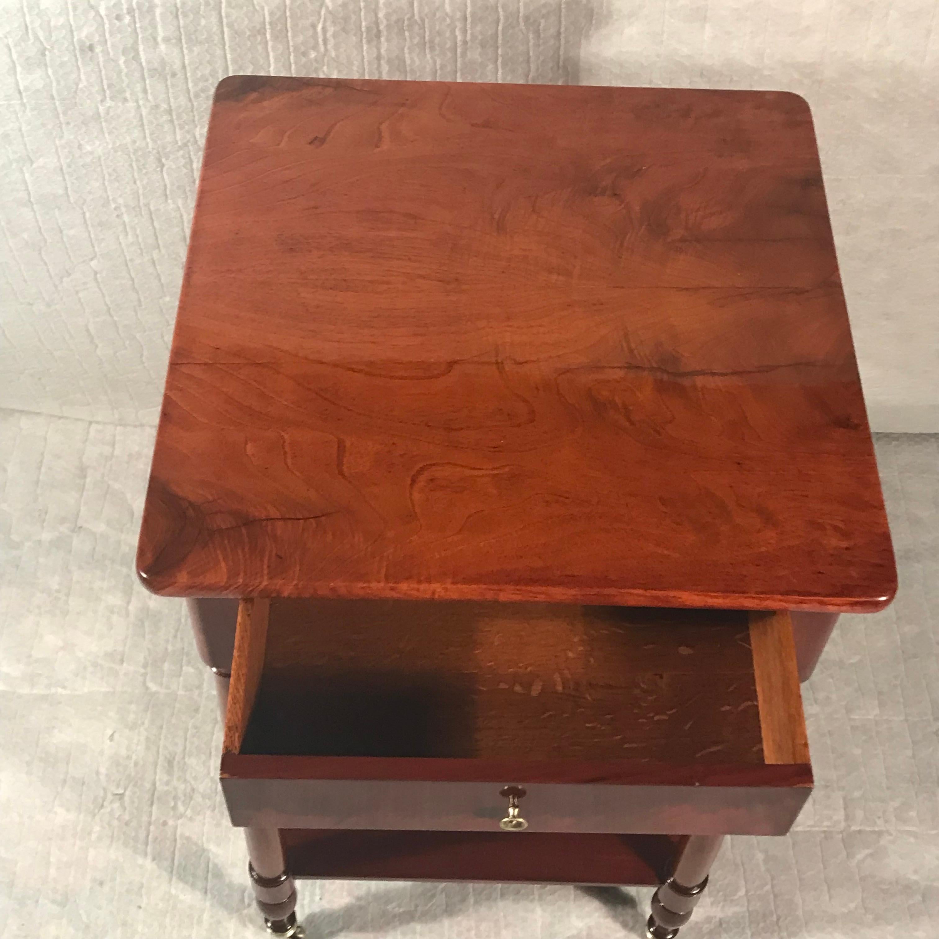 Transport yourself to the elegance of the mid-19th century with this charming side table or library table. Featuring two shelves in the lower part and standing gracefully on caster wheels, this table seamlessly blends functionality with vintage