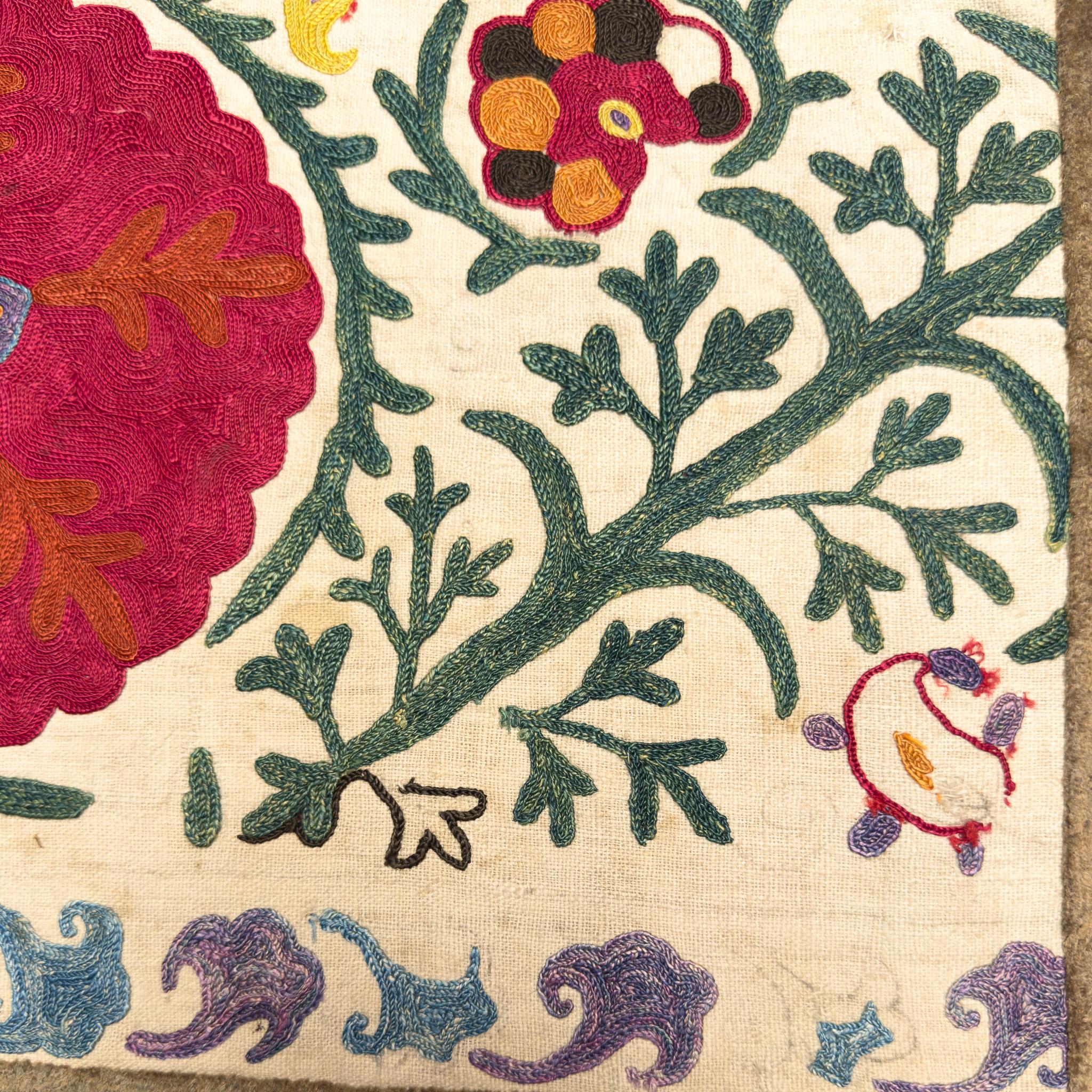 A one-of-a-kind pillow cover made from a 19th-century Bukhara suzani—an embroidered textile tradition from Central Asia, renowned for its bold floral motifs and vibrant detailing. This piece features a large central medallion surrounded by vine and