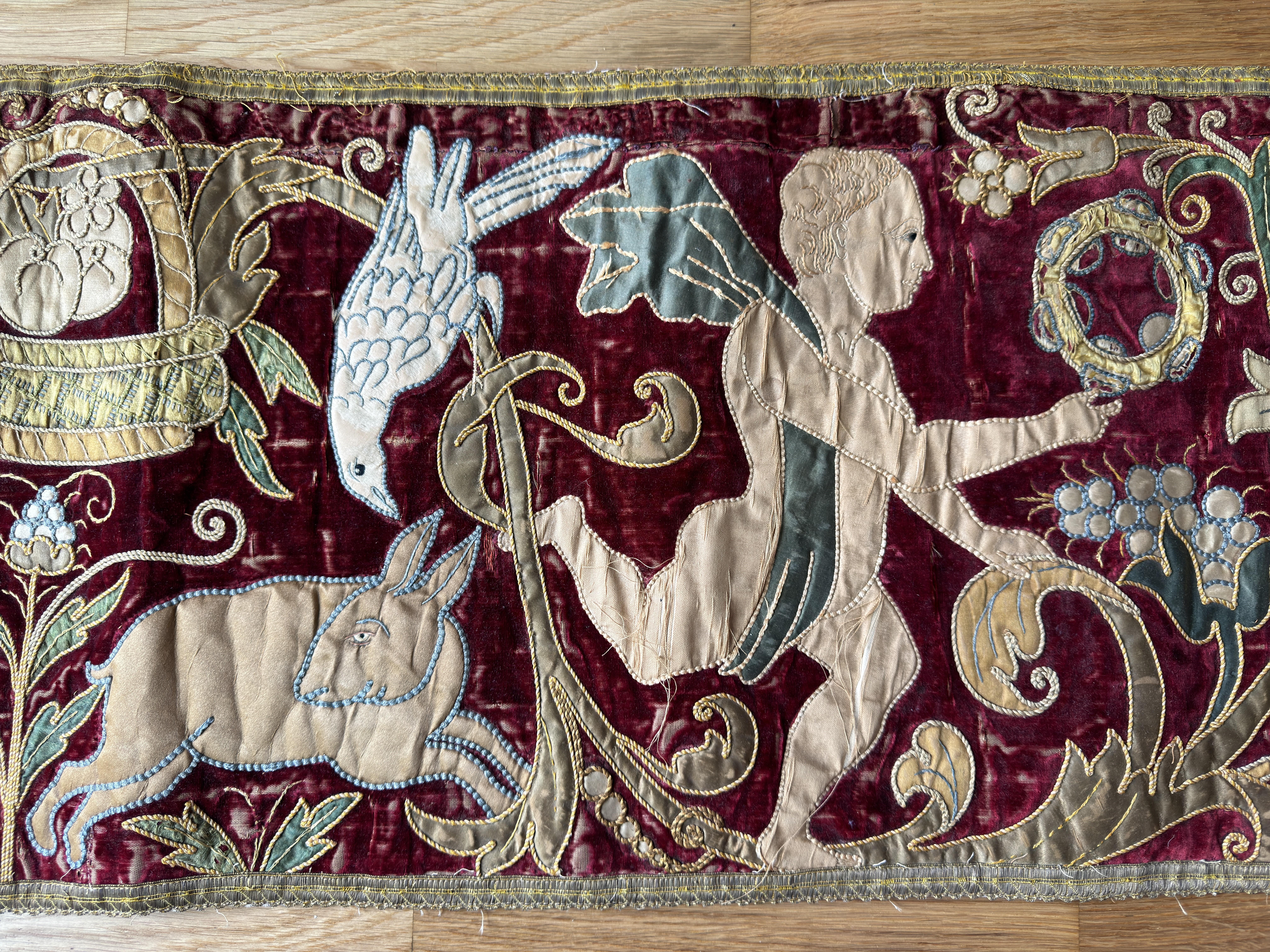 Ein feines Nadelbrett aus Seide und Samt aus dem 19. Jahrhundert, möglicherweise aus England. Die lange Tafel stellt Putti dar, die von Tieren und Vögeln umgeben ist. 

72 Zoll (183 cm) x 13 Zoll (34 cm).