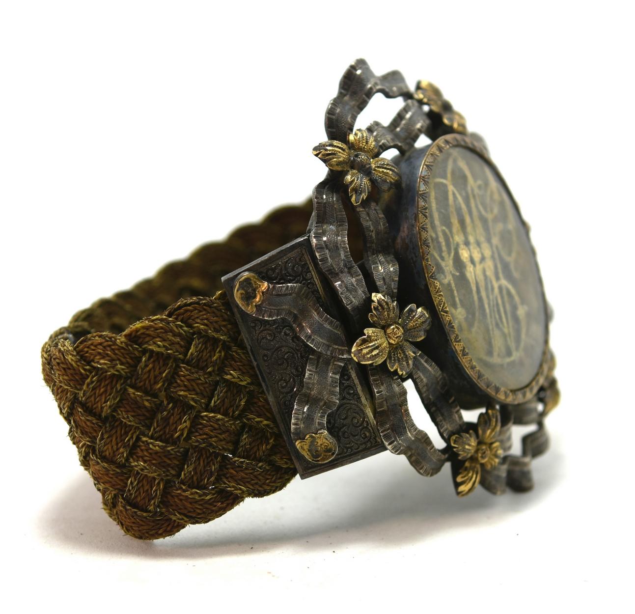 bracelet en argent et vermeil du 19e siècle avec des initiales en or décorées de fleurs et de rubans en or. Bracelet pour cheveux tressés.