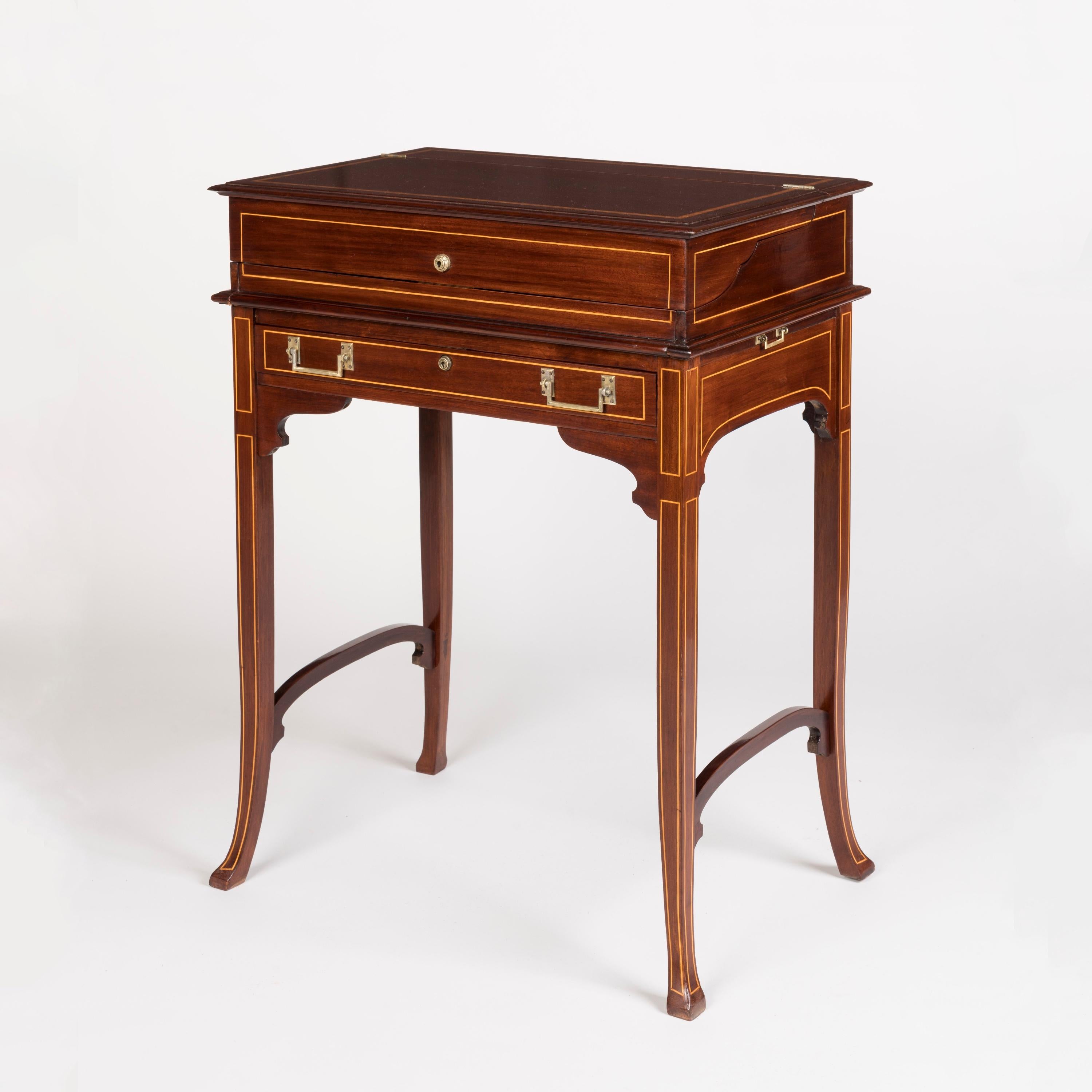 A Fine Edwardian silver-fitted dressing table.

Constructed from mahogany, with boxwood stringing and brass handles, the dressing table supported on splayed legs with stretchers and spandrels; the hinged top opening to reveal a velvet-lined and