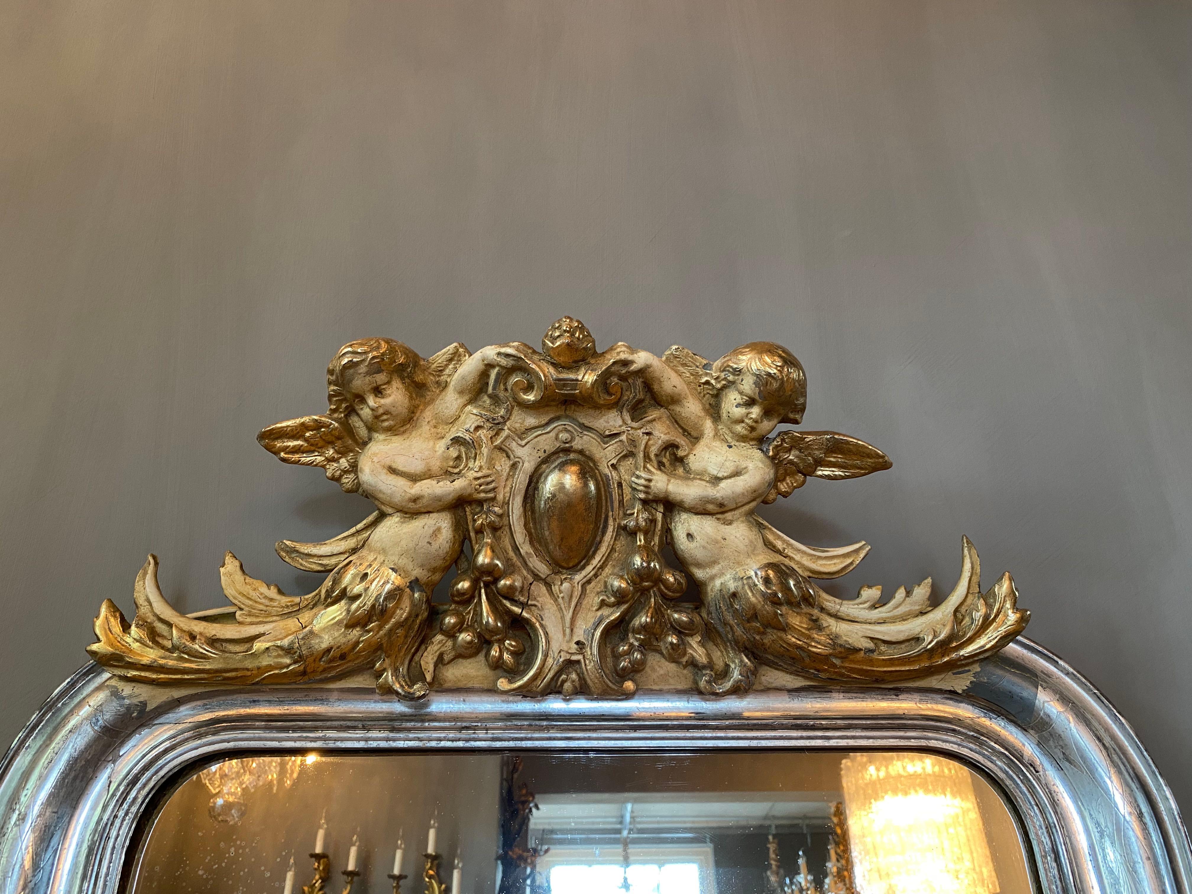 19th century silver leaf gilt French mirror with a crest with putti 1