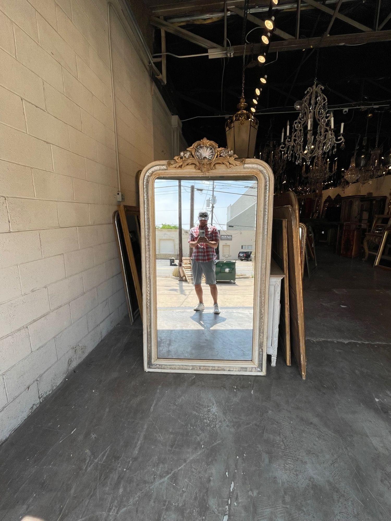 Exqusite 19th century silver Louis Philippe giltwood mirror with crest. Featuring a pretty X pattern on the wood and a beautiful carved crest at the top. There is also an antique white inner and outer border. Very special!!