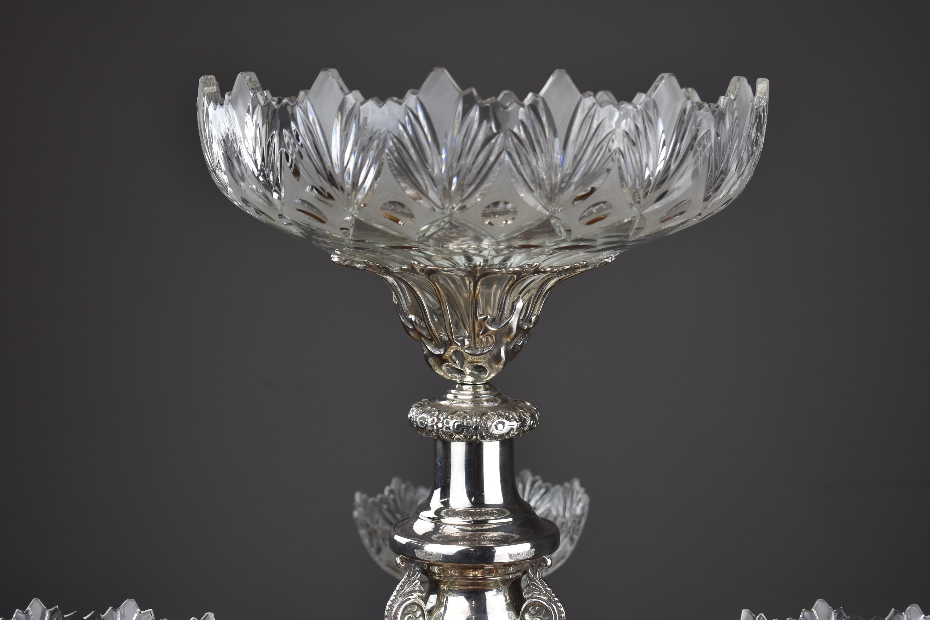 A fine quality late 19th-early 20th century silver plate centrepiece with central column and three foliate arms with leaf mounted holders supporting three etched cut glass bowls and a large top glass bowl on a foliate bordered triangular base with