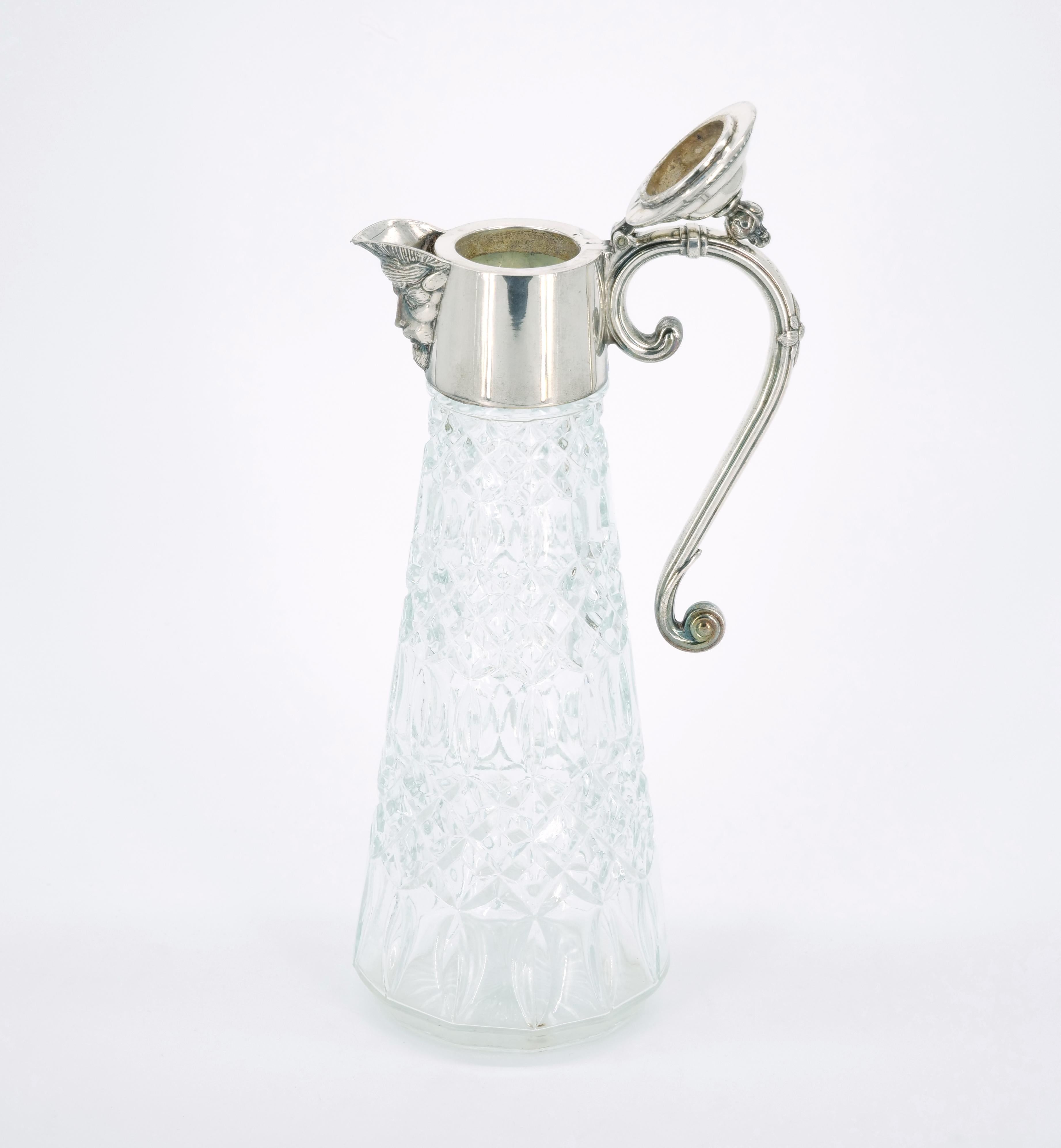 Introduce a touch of 19th-century elegance to your table or bar with this exquisite English Silver Plate and Cut Glass Claret Jug from the mid-19th century. The pitcher, designed in the Edwardian style, boasts a diamond-cut glass body, creating a