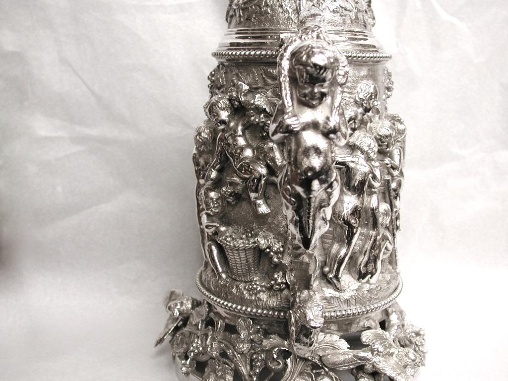 Bacchanalian silver plated quart lidded tankard.
Embossed with cherubs, birds, ram's heads,
griffins and grape and vine leaves in high relief.
Probably French, dated circa 1870.