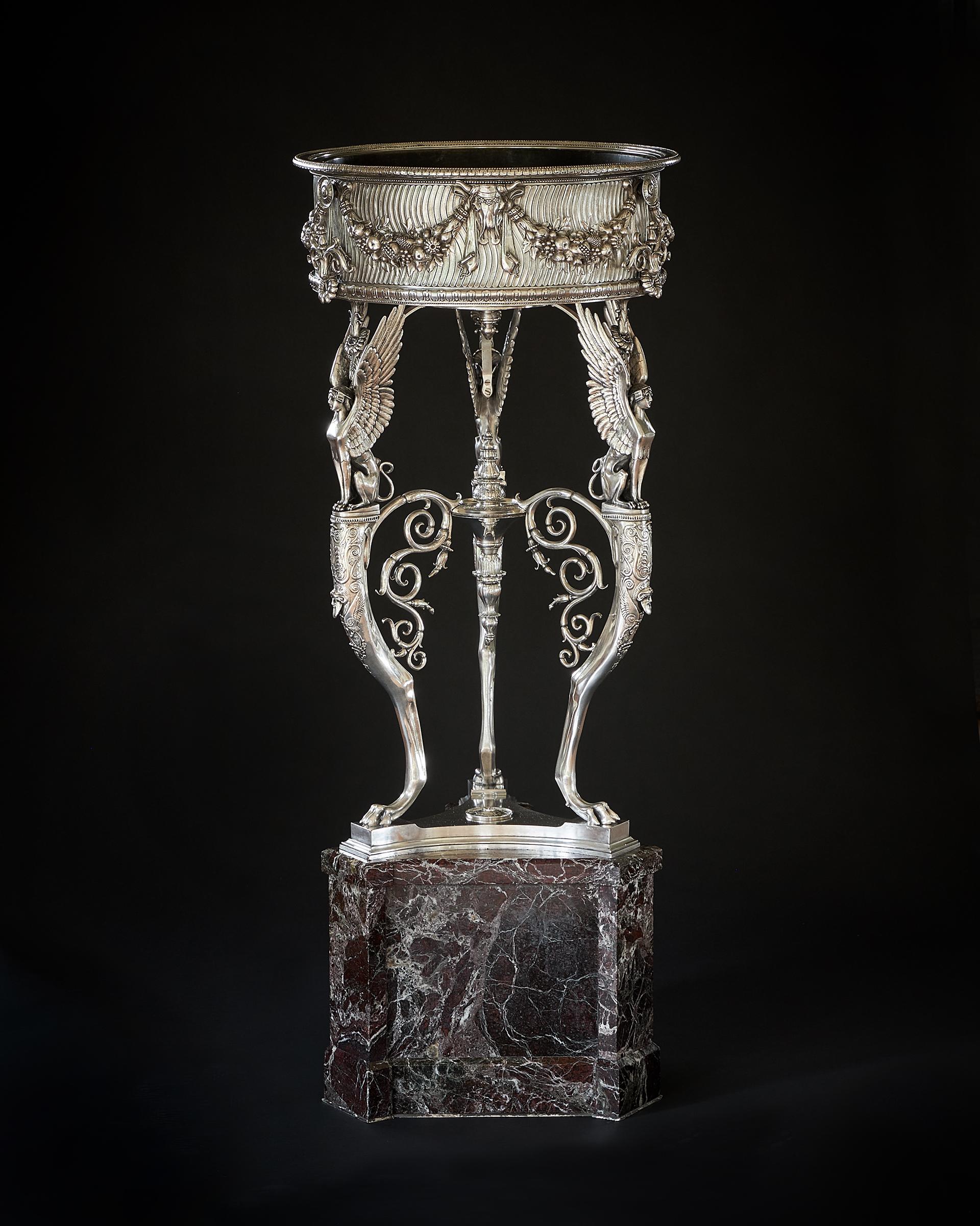 A French silvered-bronze athénienne by Ferdinand Barbedienne, Paris, last quarter 19th century with a revolving liner, the frieze applied with bucrania suspending ribbon-tied berried laurel swags above a border of bellflowers on a stippled ground