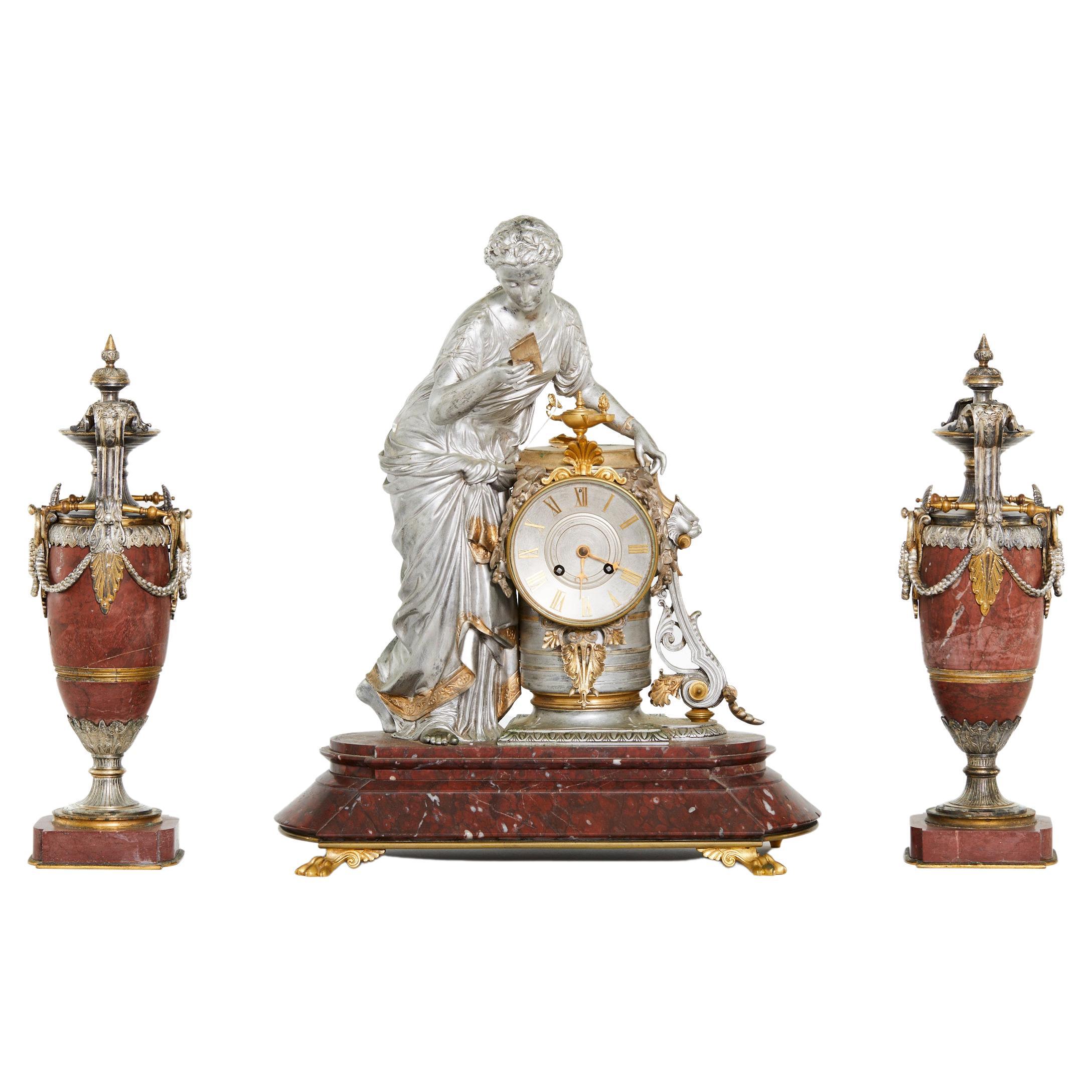 Mid 19th Century French silvered bronze and rouge marble three piece decorative clock garniture set . The clock features a classical figured woman with draping garments and flanked by two matching urns . Eight day brass / porcelain face time and