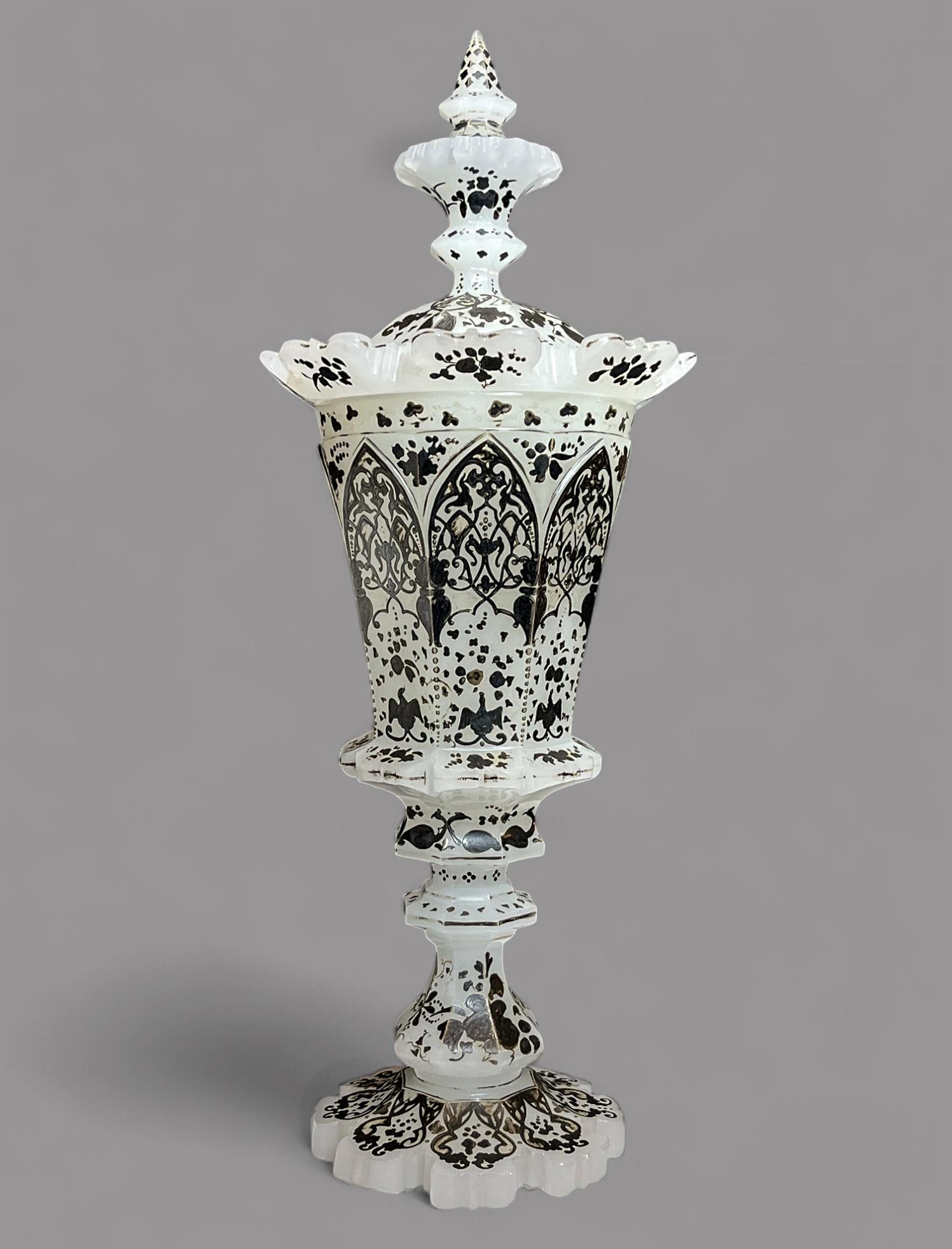 Importante Pokal de vidrio opalino esmaltado en plata del siglo XIX - un recipiente facetado en forma de torrecilla, decorado con diversos follajes y flores; elevado sobre una base de pedestal; la tapa abovedada con remate de varios niveles
