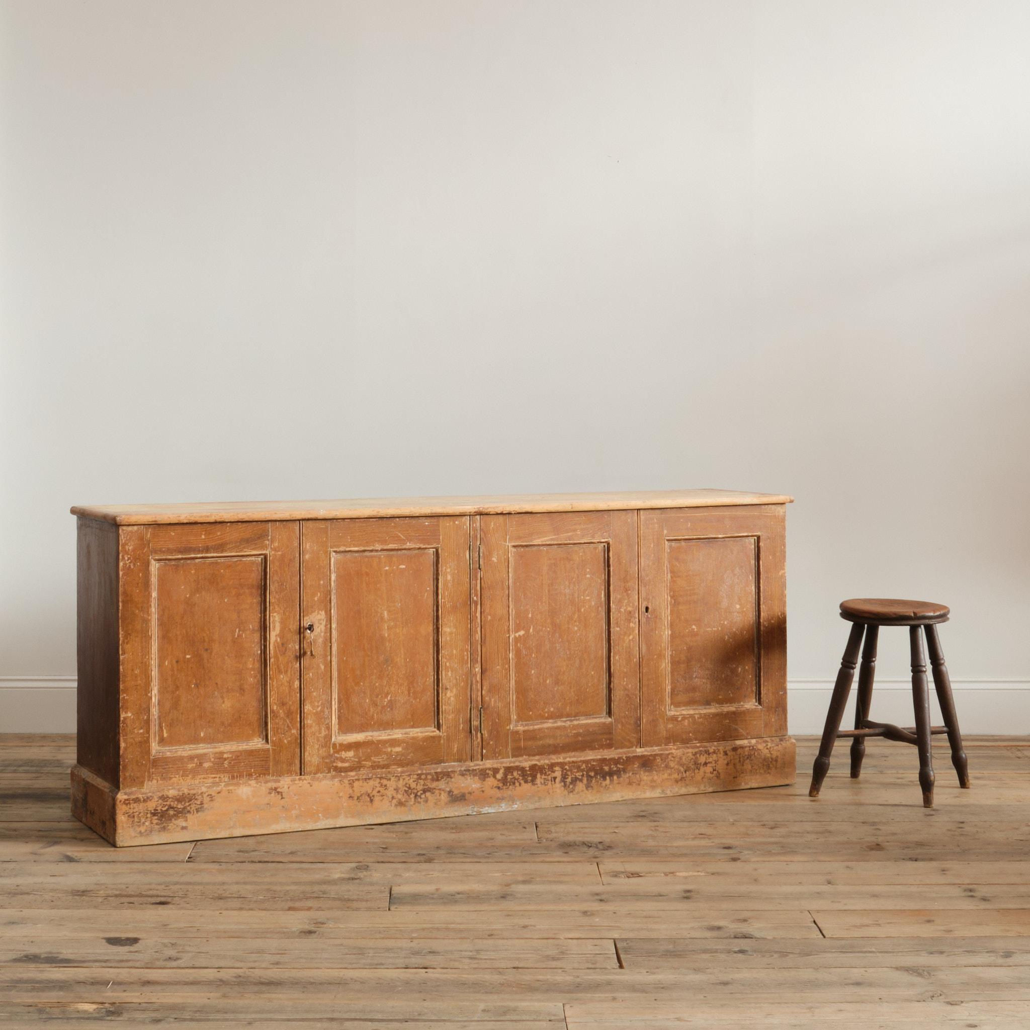 Base de commode en pin du XIXe siècle, grattée à sec pour révéler la finition en chêne simulé d'origine. 4 portes à panneaux conservant les serrures et la clé d'origine. Les deux côtés ont une seule étagère centrale avec un intérieur propre et