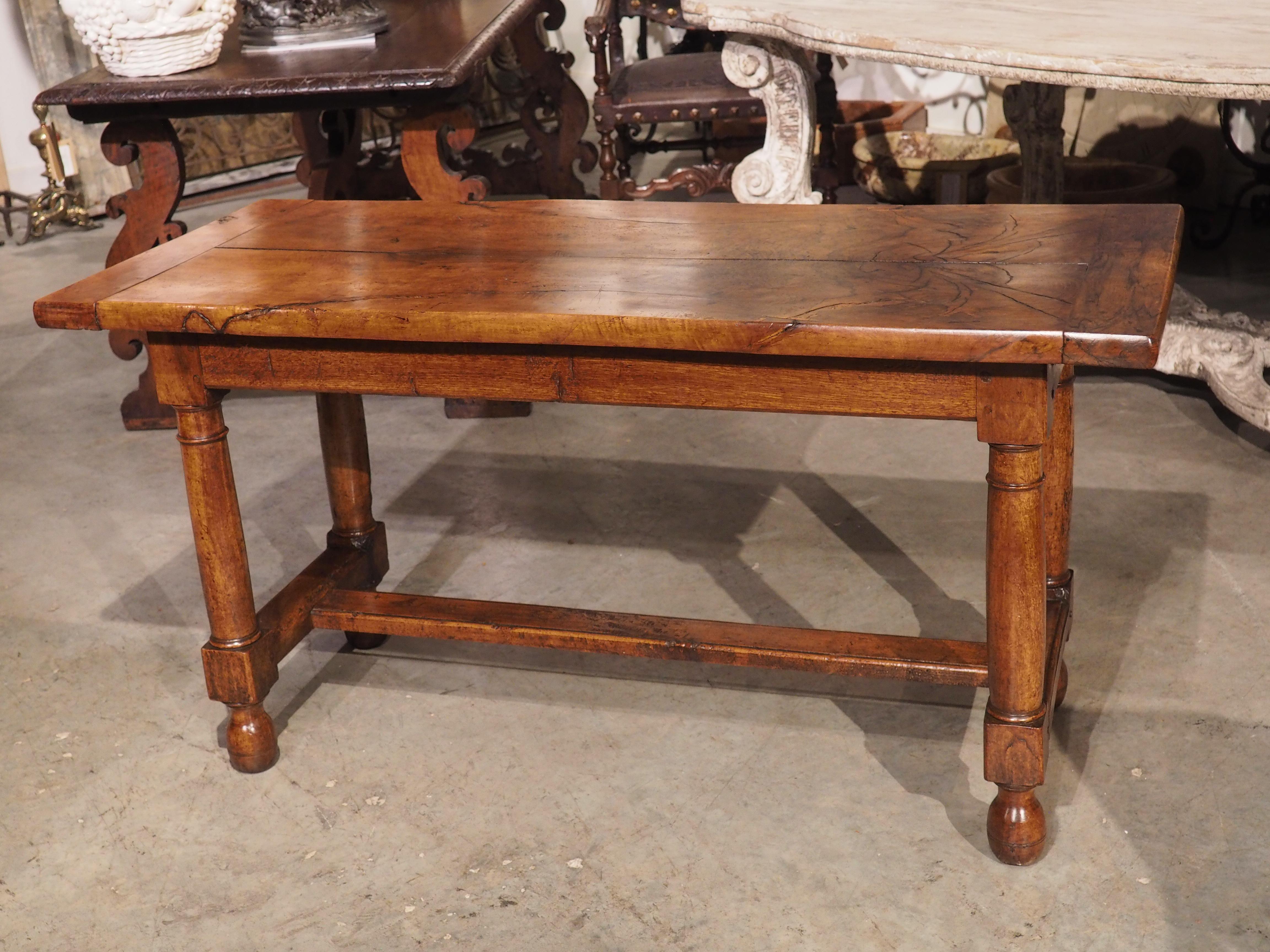 This handsome antique table is from Normandy and features an interesting single cut plank top with a beautiful burl wood grain.  The thick walnut plank top was originally cut into two sections to provide longevity and stability to the wood.  Larger