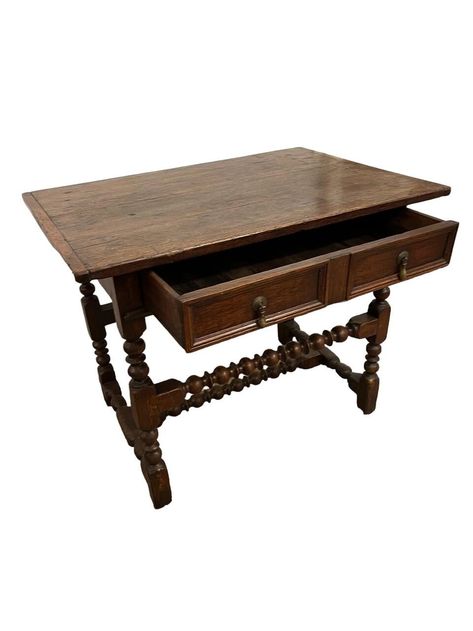 Add character to your space with this 19th Century English Oak Single Drawer Bobbin Leg Table. Crafted with rich oak, loaded with patina, it features a single drawer for convenient storage and distinctive bobbin legs and stretchers for a touch of
