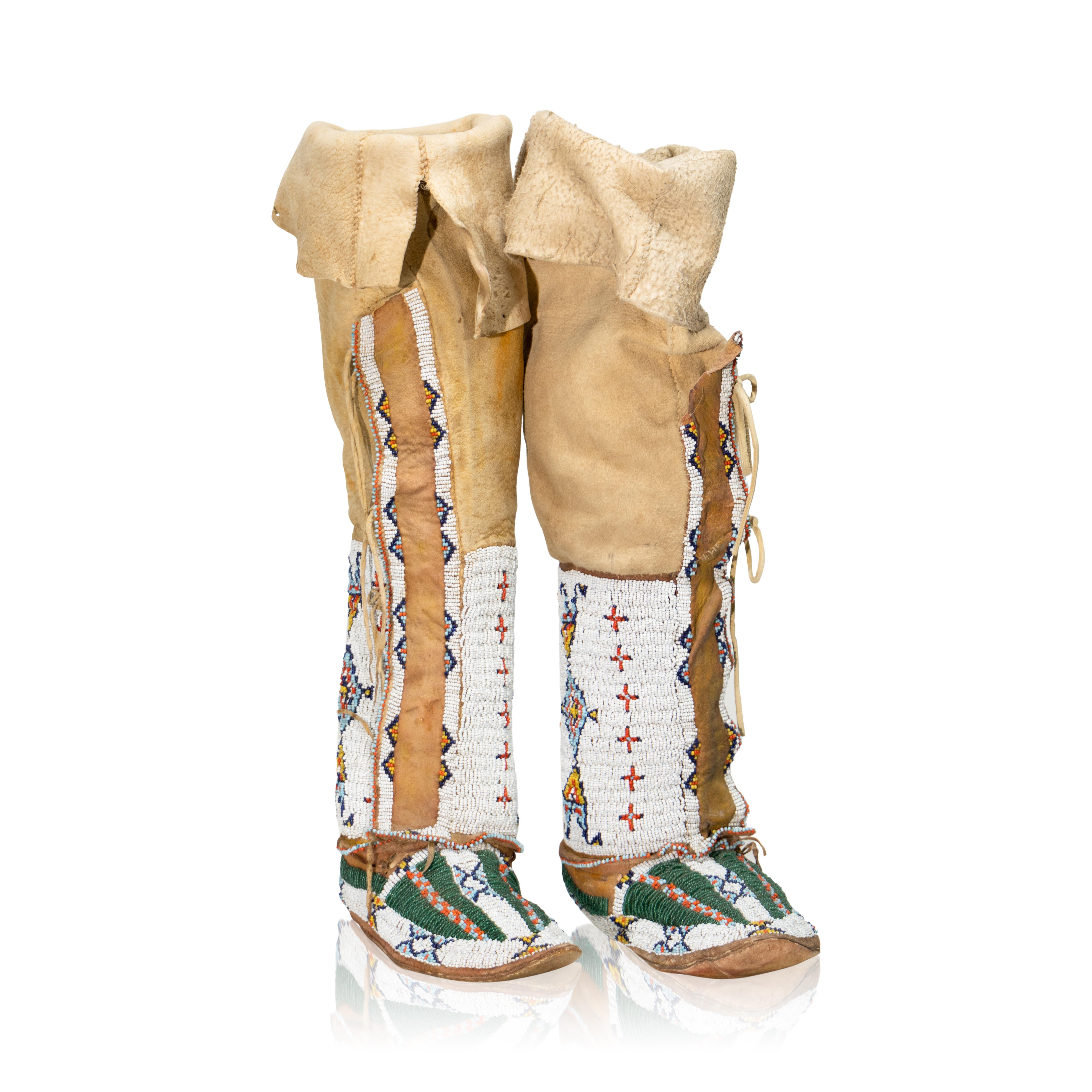 This is an outstanding set of authentic original beaded hide high-top / high-top moccasins with hard parfleche soles from the Sioux Native American Indians dating to circa 1880. The set shows stiff Indian tanned hide moccasins with hard parfleche