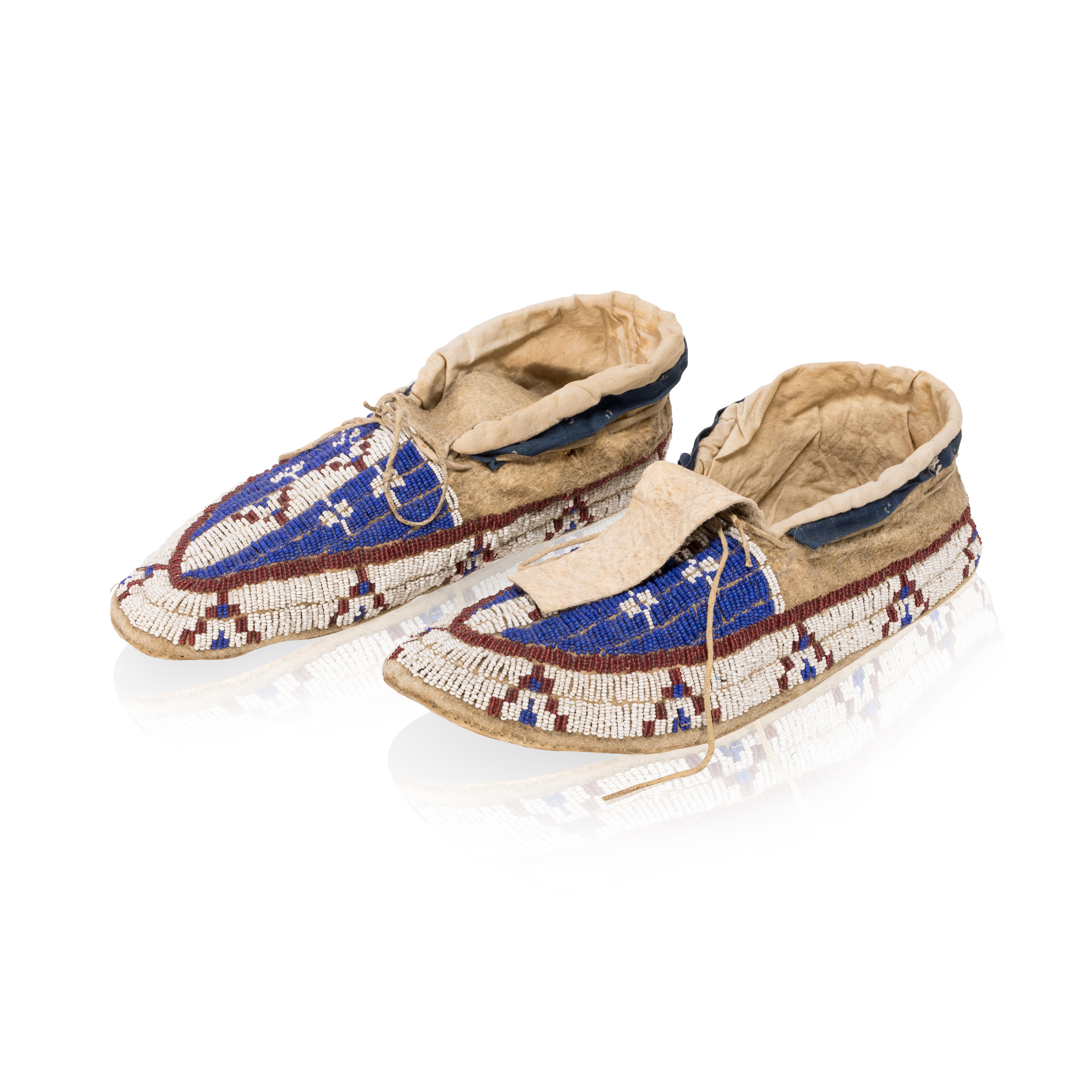 Sioux fully beaded moccasins. Red, white and blue with geometric stacked colors. Hard soles, cotton cuff edging.

Period: Late 19th Century
Origin: Great Plains - Sioux, Native American
Size: 10 1/2
