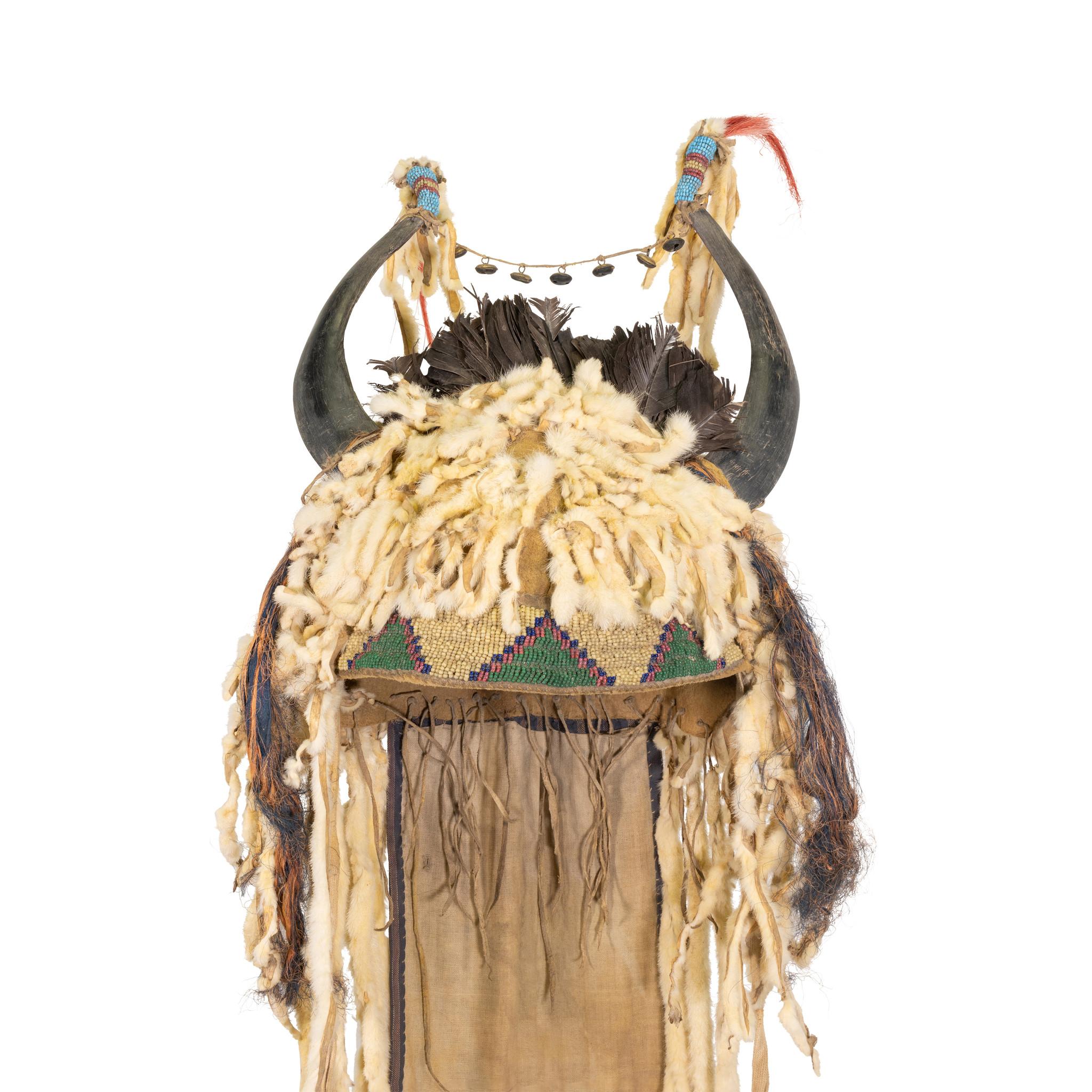 Véritable bonnet sioux en corne fendue du 19e siècle, fabriqué par les Amérindiens, avec doublure en peau de buffle. De longues queues d'hermine pendantes, dont les extrémités sont perlées de jaunes gras et de cœurs rouges garnis de crins de cheval.