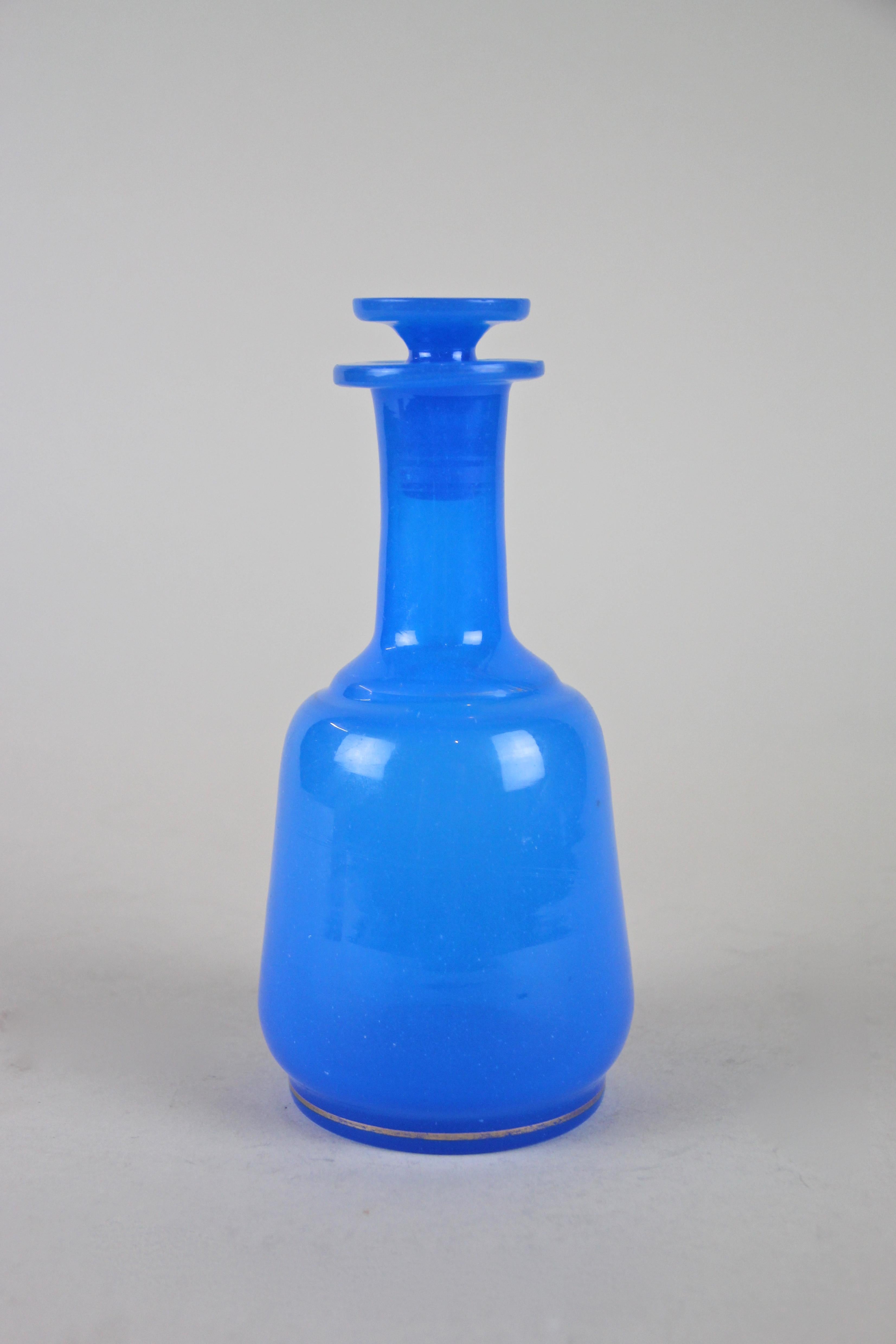 Gorgeous blue Biedermeier glass bottle from the mid-19th century in Austria, circa 1840. This beautiful shaped glass bottle comes with a glass plug showing a nice design on top. A golden line around the base builds a nice contrast to the great sky