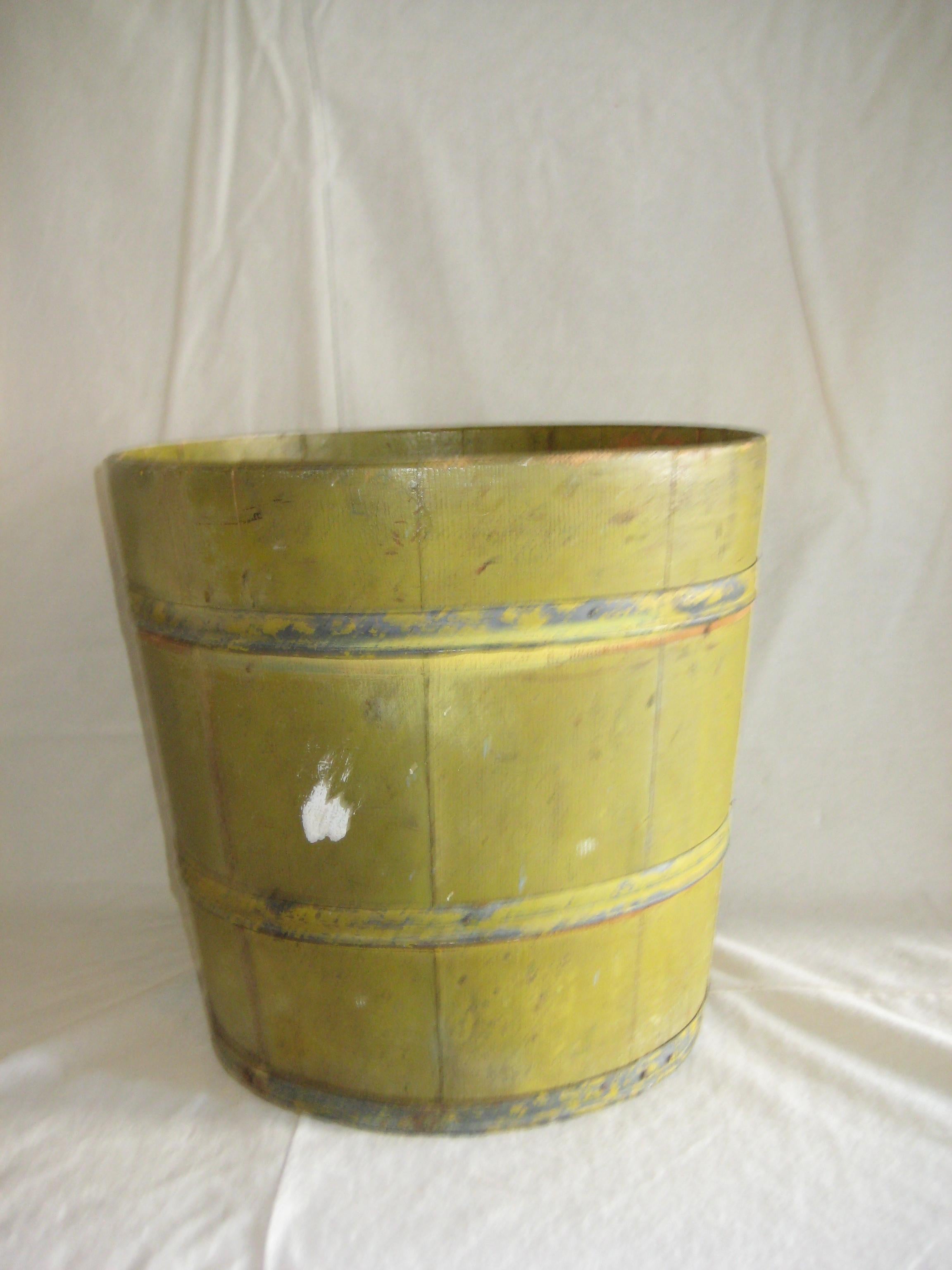 Mid 1900’s authentic yellow wood slat bucket with metal bands, purposed in the construction field for handling sticky, chunky mud. 
 