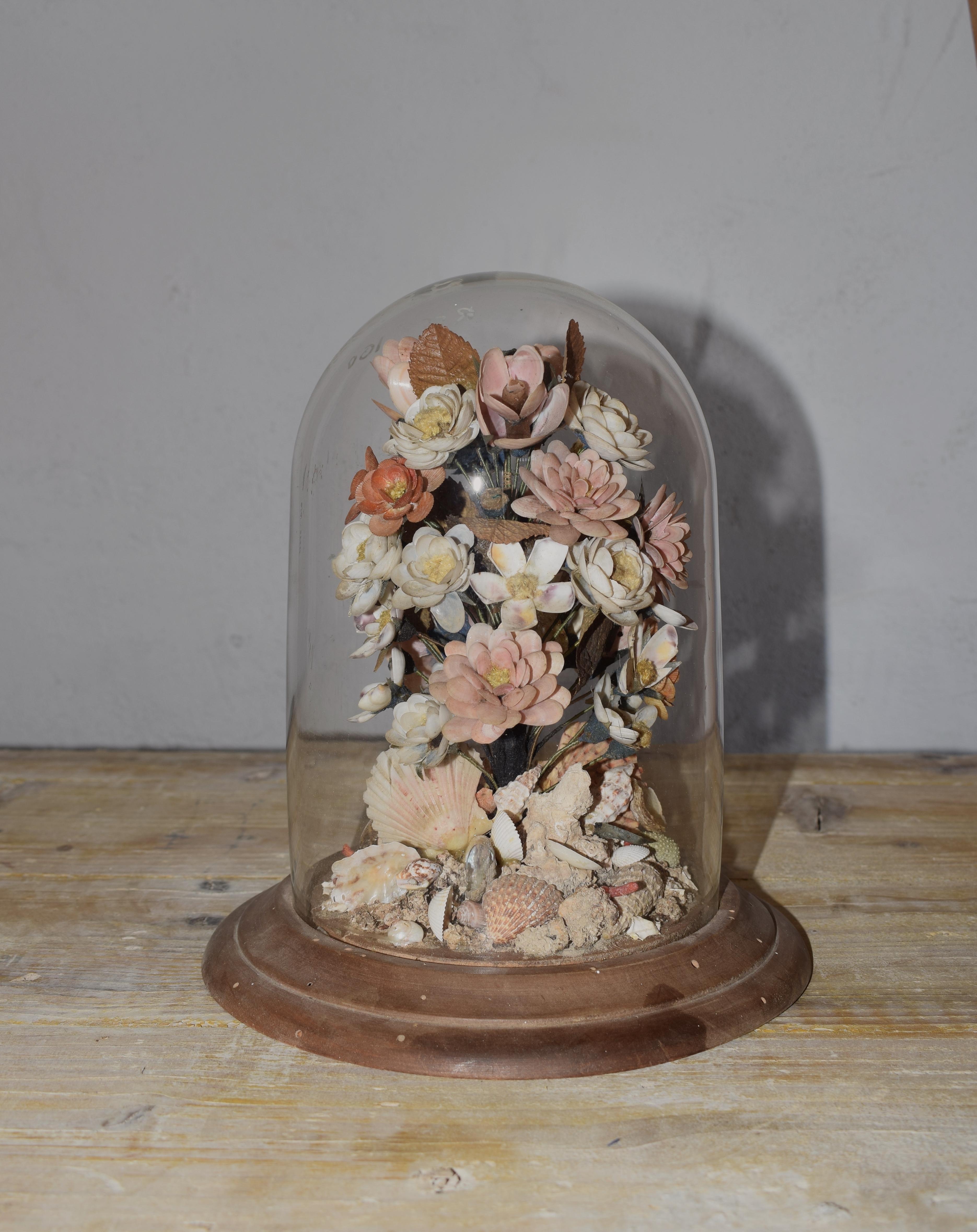 A wedding bouquet seashells bouquet also known as ´Sailors Valentines´. These works of art are made principally of hundreds of tiny seashells with some crustaceans. This floral decoration is covered in a large elongated glass dome whilst the flowers