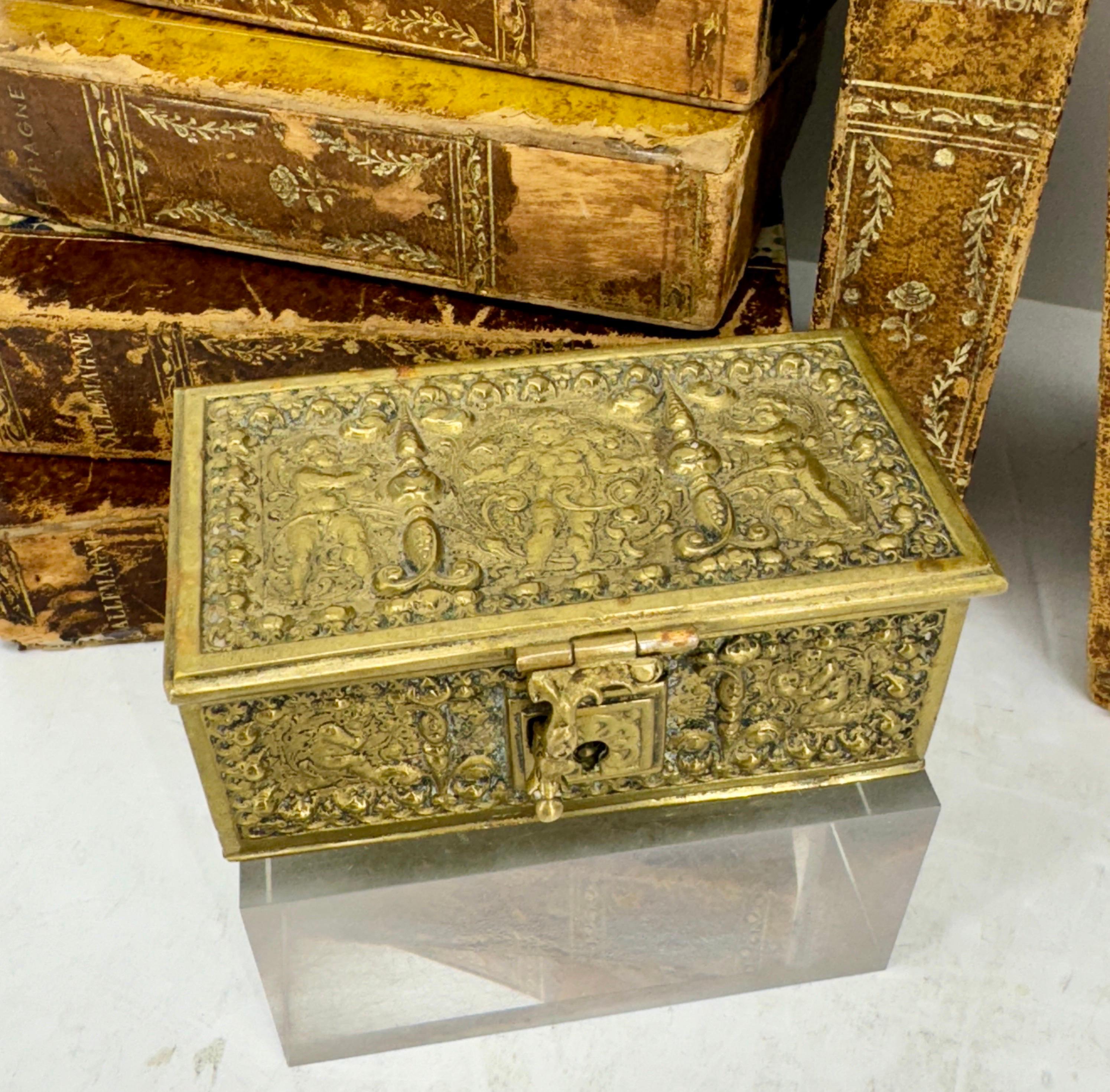 Petite boîte à bijoux baroque en bronze doré repoussé avec compartiments intérieurs et clé.