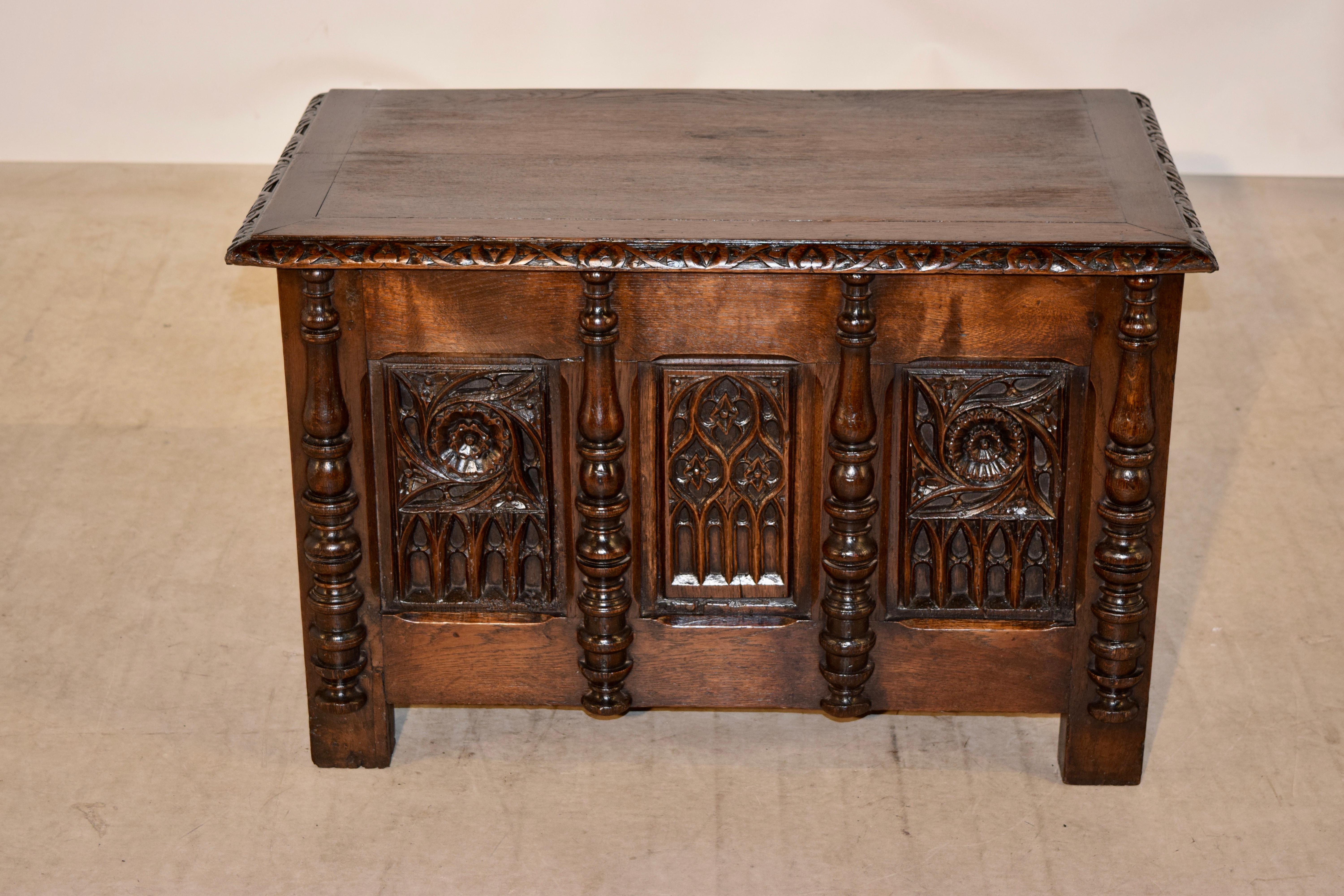 19th century small blanket chest from England with a banded top which has a beautifully hand carved decorated beveled edge following down to raised paneled sides and three raised and hand carved decorated panels in the front, flanked by applied half