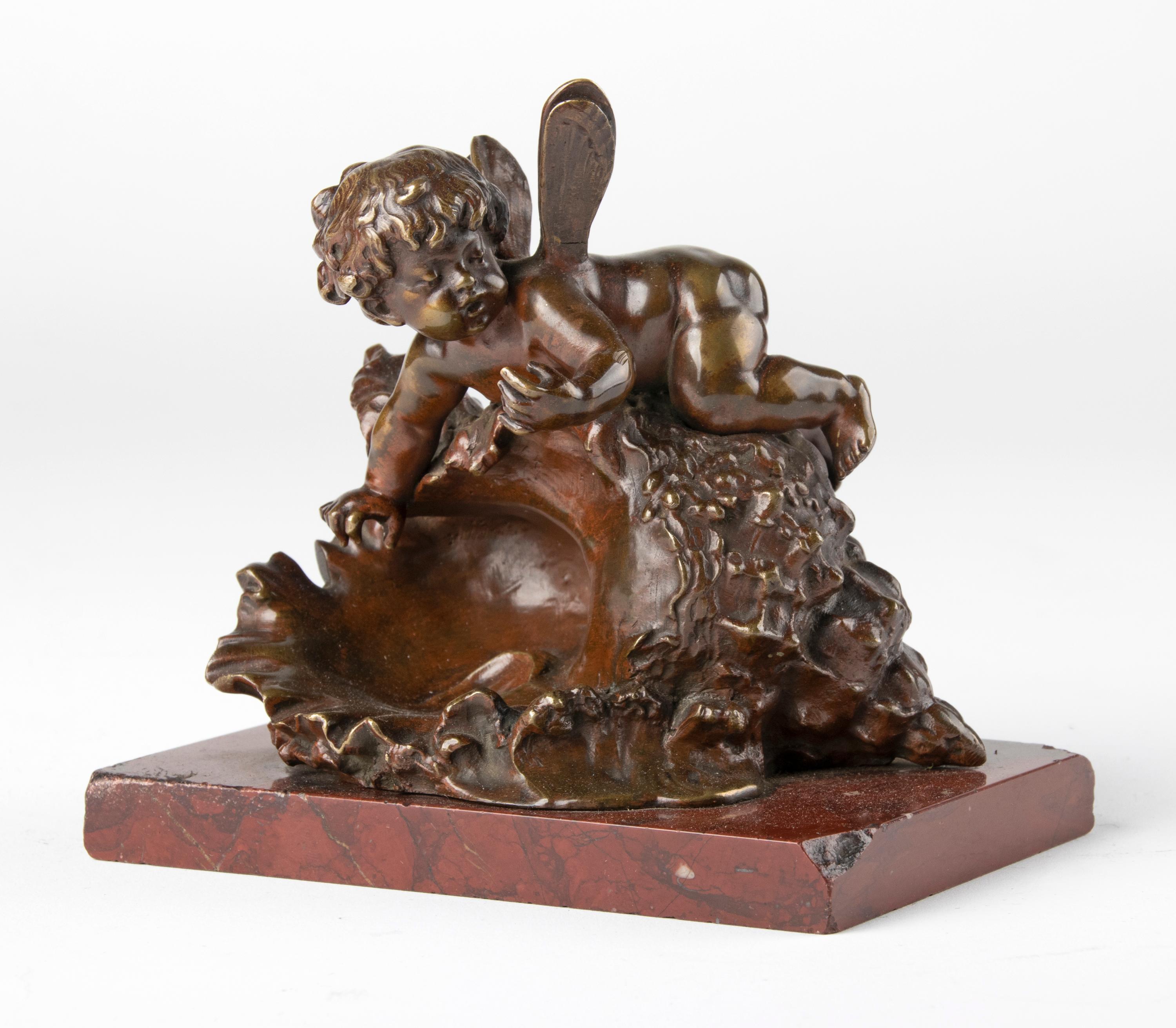 Cute little bronze statue by the famous French sculptor Auguste Moreau. The figurine represents a small cherub sitting on a shell. The figurine is very detailed and beautifully refined. The bronze has a beautiful old patina and stands on a simple