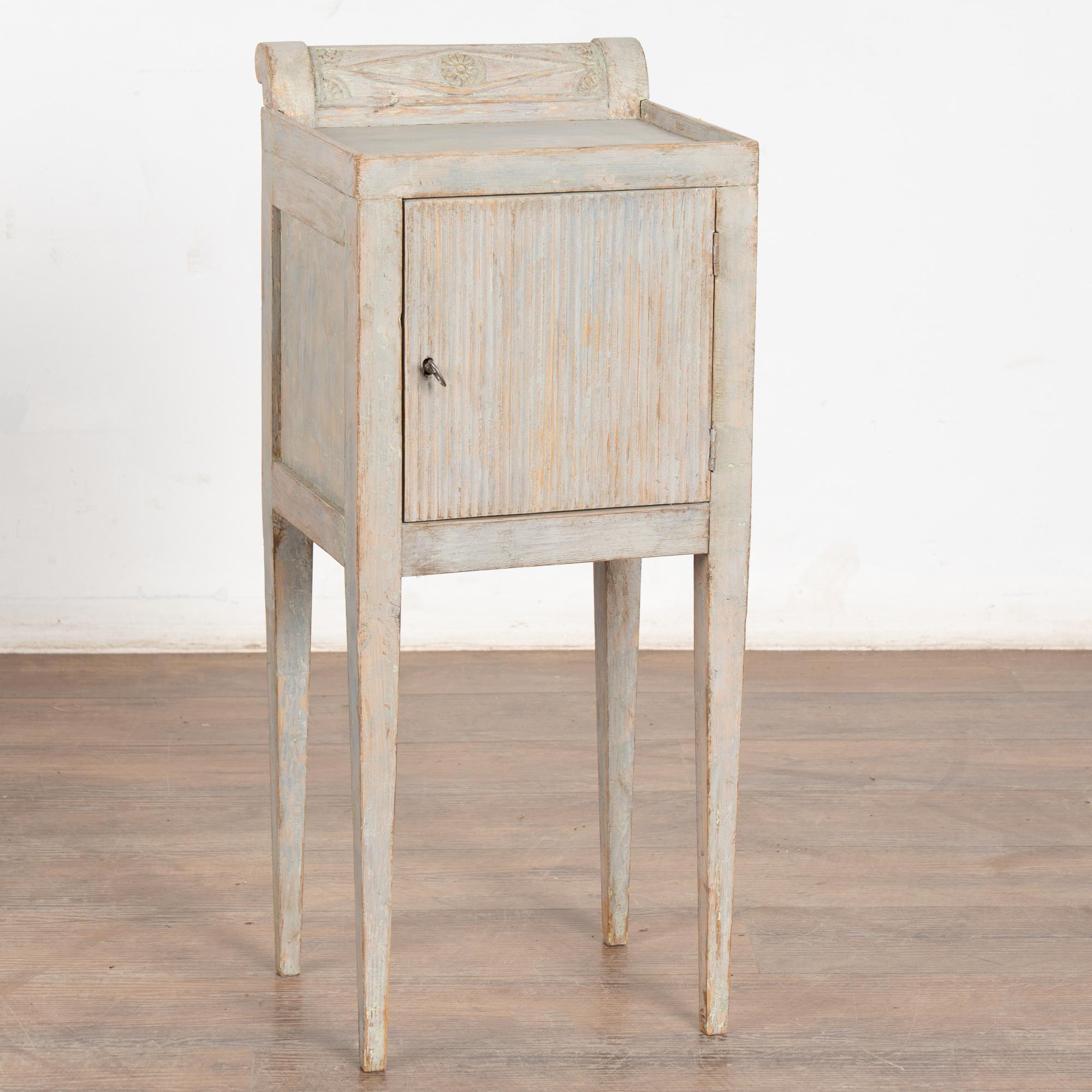 Piccolo mobile country svedese dipinto di grigio che poggia su gambe affusolate; può essere utilizzato anche come comodino o tavolino.
Schienale curvo decorativo; un'unica anta scanalata dell'armadio si apre con la chiave, la serratura non
