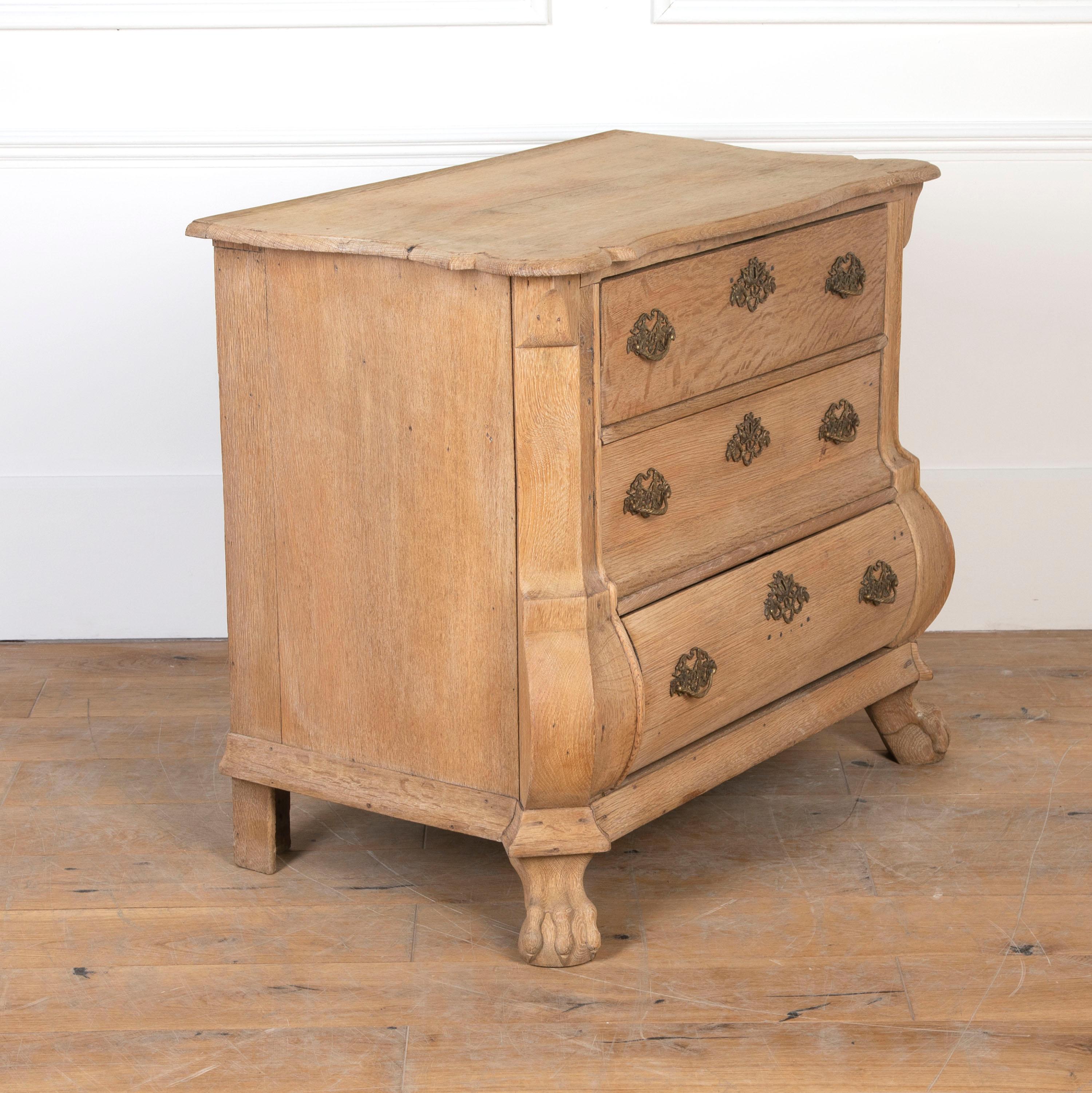 Small early 19th Century Dutch bombe commode.
This commode is composed of solid bleached oak with its original brass fittings.
The whole is supported on hand-carved claw feet. This is a robust piece with strong character, that will undoubtedly add