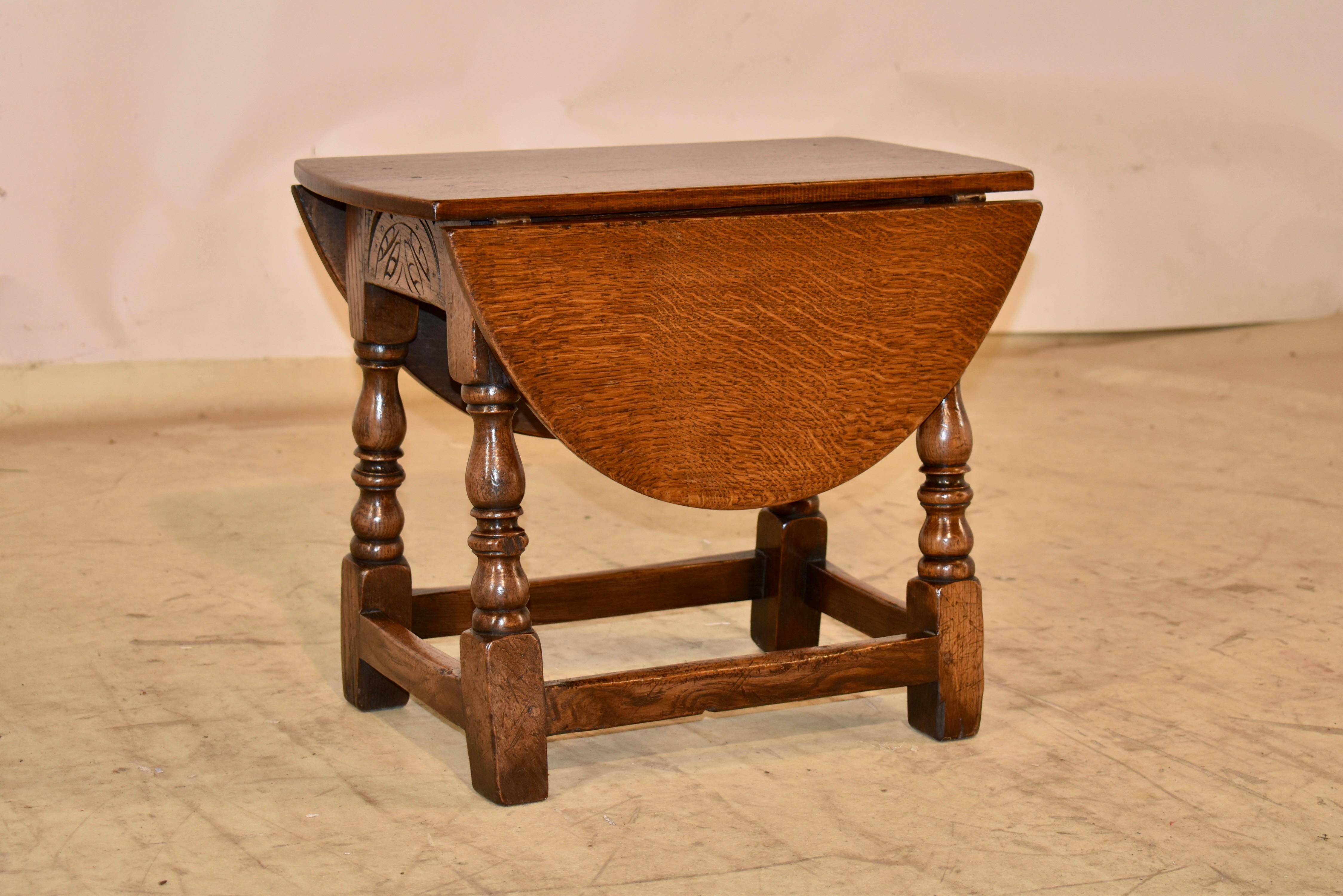 Late 19th century small oak drop leaf table from England.  

The top has lovely color and pegged construction, following down to nicely carved decorated aprons on the ends.  The table has two dropped leaves, which measure 28 x 21 when extended in