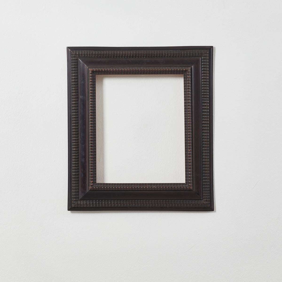 Made in Italy well over one hundred years ago, the striking ebonised wooden ripple frame is made in an 17th and 18th Century Dutch ripple style. Its surface is intricately detailed and textured with carved patterns of indentations and