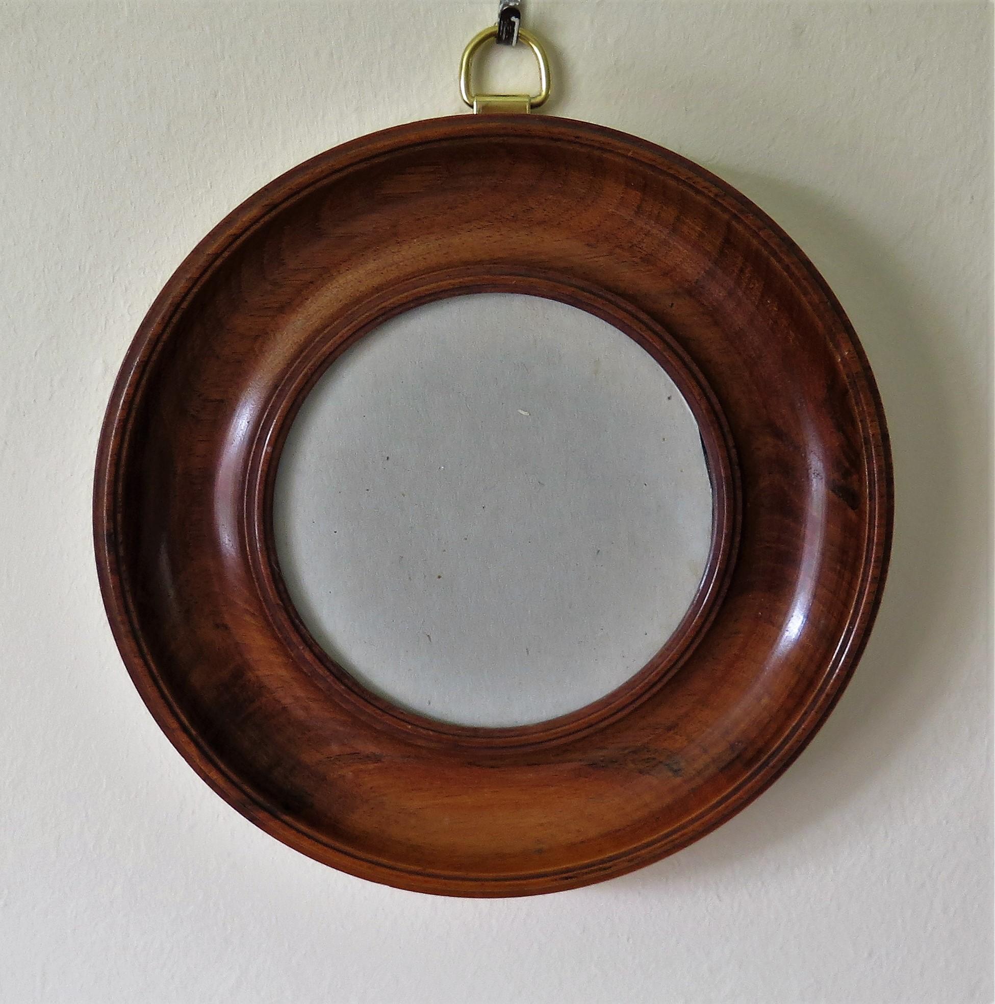 This is a small, wall hanging, picture or photograph frame made of hand-turned solid Mahogany and dating to the English Victorian period, circa 1870.

The frame is made of solid mahogany which has patinated to give a lovely mellow color and with a