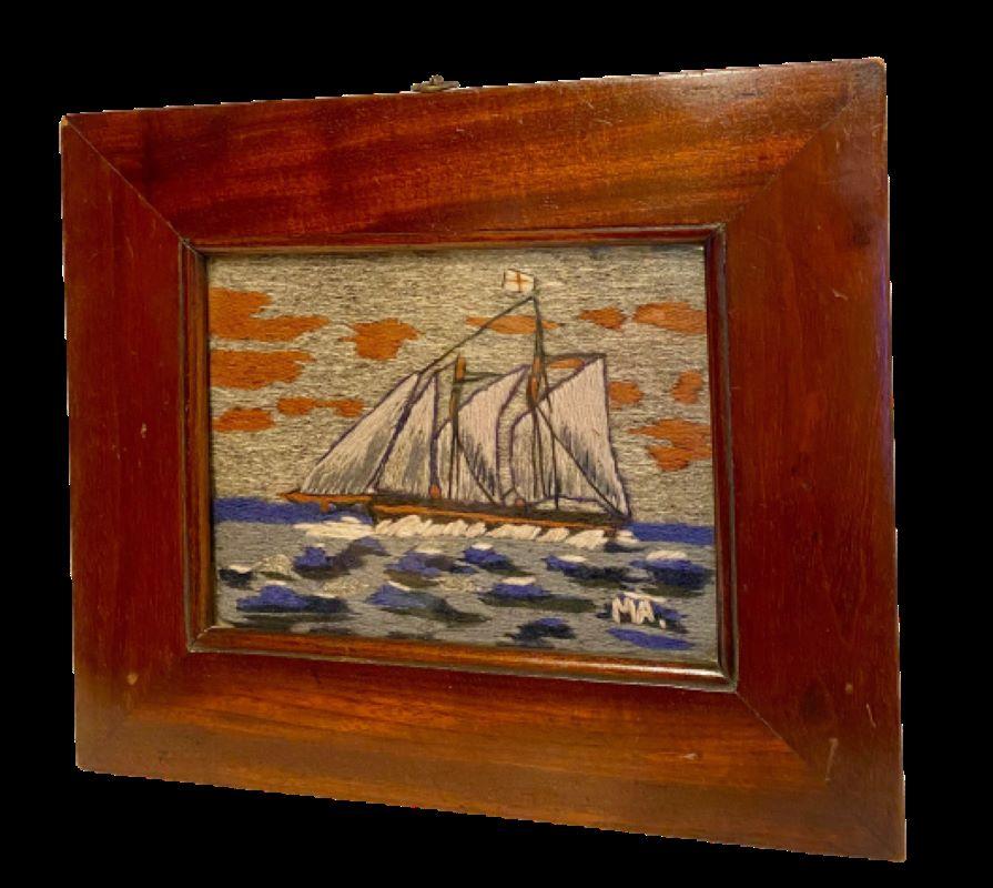 19th century small Sailor's Woolie with Schooner, signed M.A., circa 1870, a hand-stitched sailor's woolwork with larboard side view of a schooner under full sail, flying the British ensign off the main gaff, and England's St. George's Cross at the