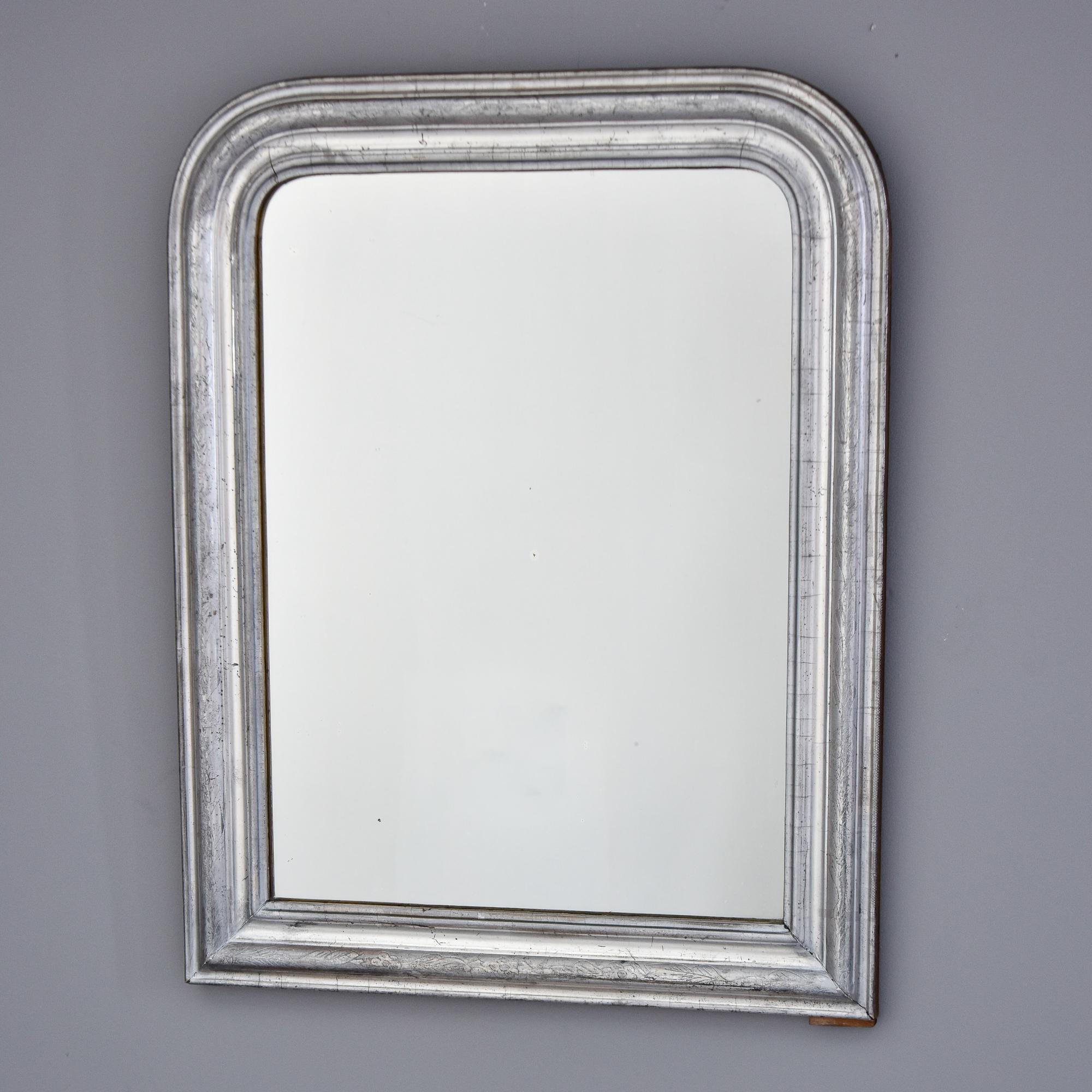 Found in France, this circa 1860s silver gilt Louis Philippe style wood frame has a subtle etched design of leaves and vines around the edge. Newer mirror. Unknown maker. 

Actual Mirror Size:  21.75” h x 16” w