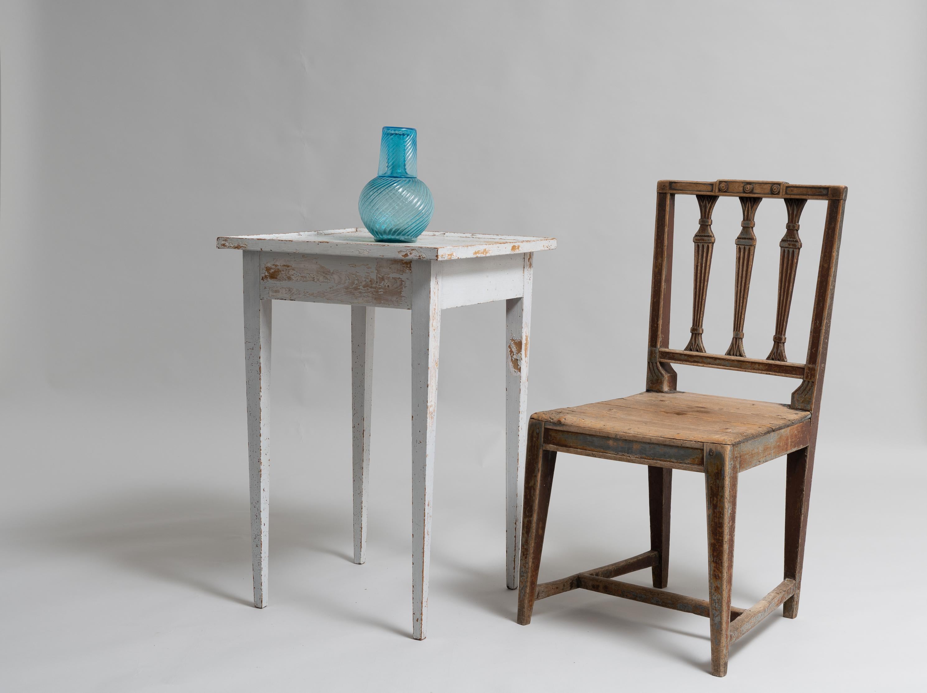 Northern Swedish white side table in Gustavian Style. The table is from the early 1800s, around 1820 and has its origin in a small village called Roren. The table is an unusual model with a rectangular table top with a rim around and straight