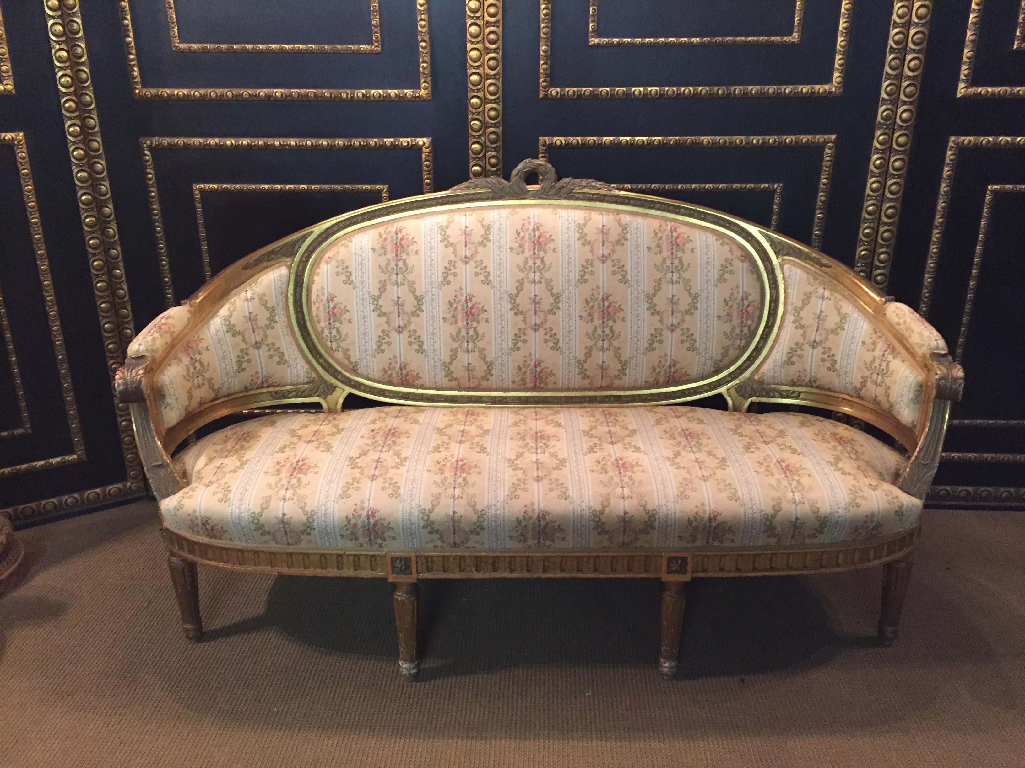Solid beechwood, finely carved,
poliment gilded and partial sheet gilded. Cambered and carved frame on carved, tapering legs. Curved armrests. Flanked by relieved leaf rosettes. Rising armrests in medallion-shaped back frame with carved crown