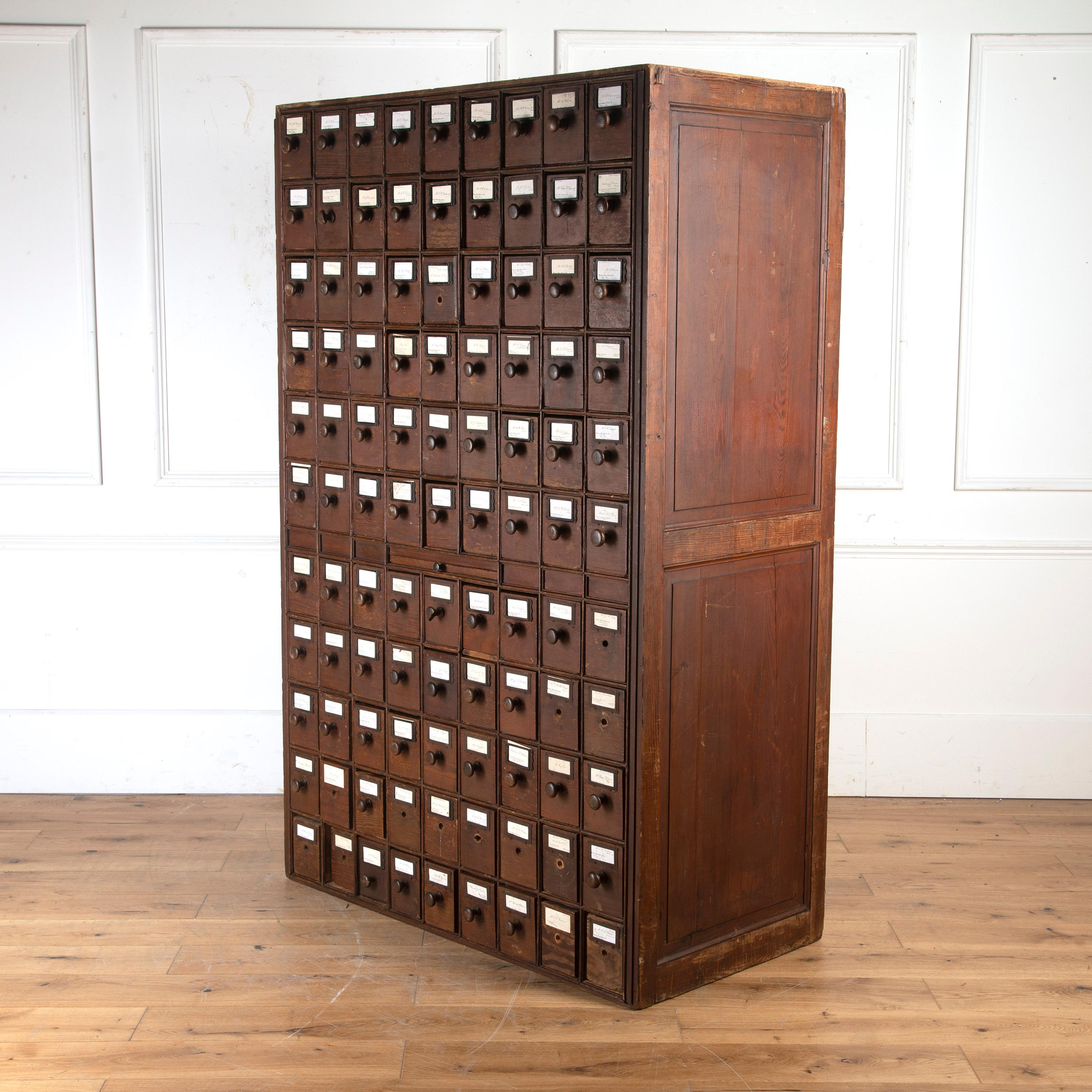 Fantastic late 19th century stained pine solicitor's filing cabinet.

This rare cabinet comprises a bank of 99 drawers, all set within a tall cabinet with panelled sides. Each drawer features dipped sides to allow easy access to its contents.