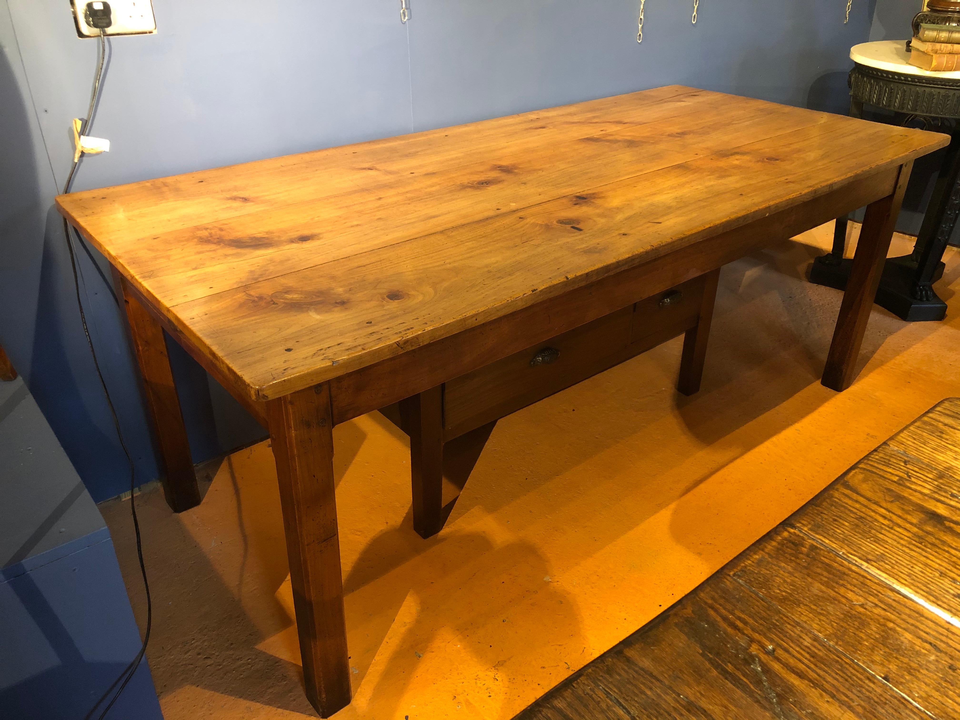 Solid cherrywood French farm house table of good proportions, exceptional color, figuring and patina. Good size drawers at each end of the table, the solid cherry top and frieze on four square chamfered legs.