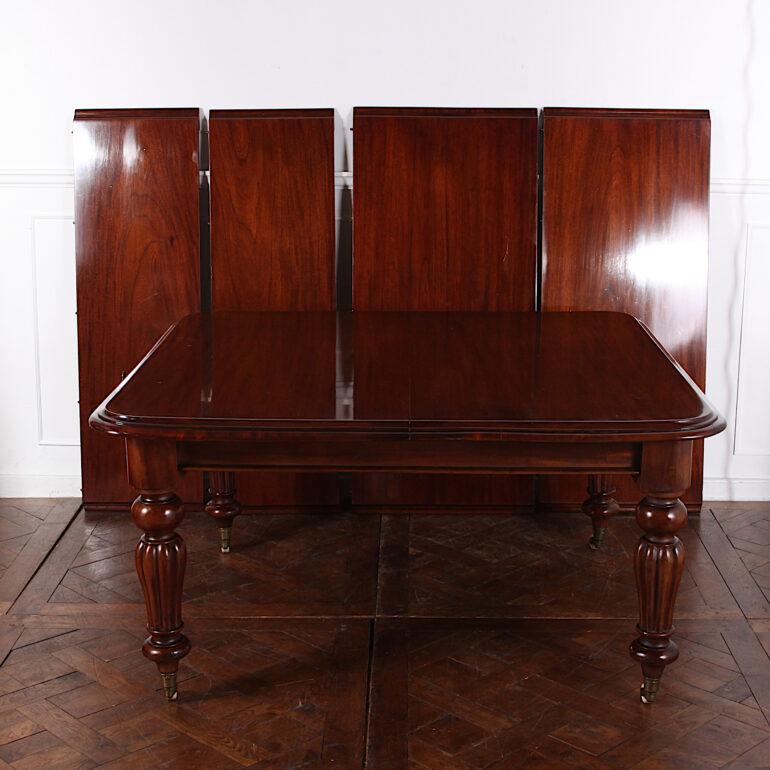 Large English Victorian solid mahogany extending dining table with four leaves. Dating to 1860 or 1870, this table has the ‘crank’ mechanism typical of the era allowing it to open up to take various combinations of the four plank leaves depending on