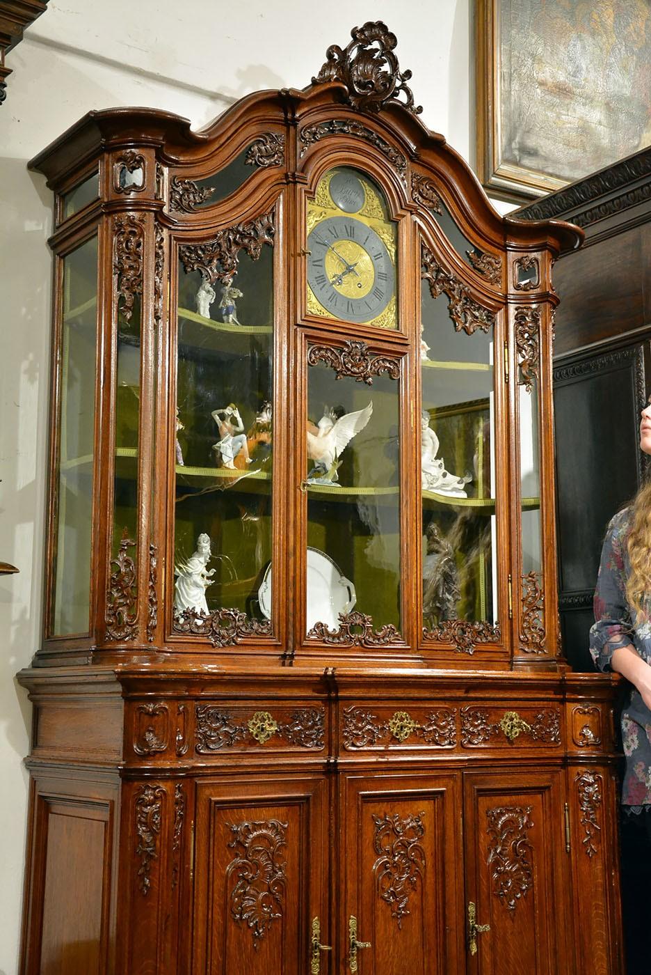 An unusual Rococo style cupboard with clock. Made of oak, dated to the second half of the 19th century.
Furniture after professional renovation.
Noteworthy are the original, old cast glass, openwork decorations characteristic of the style and,
