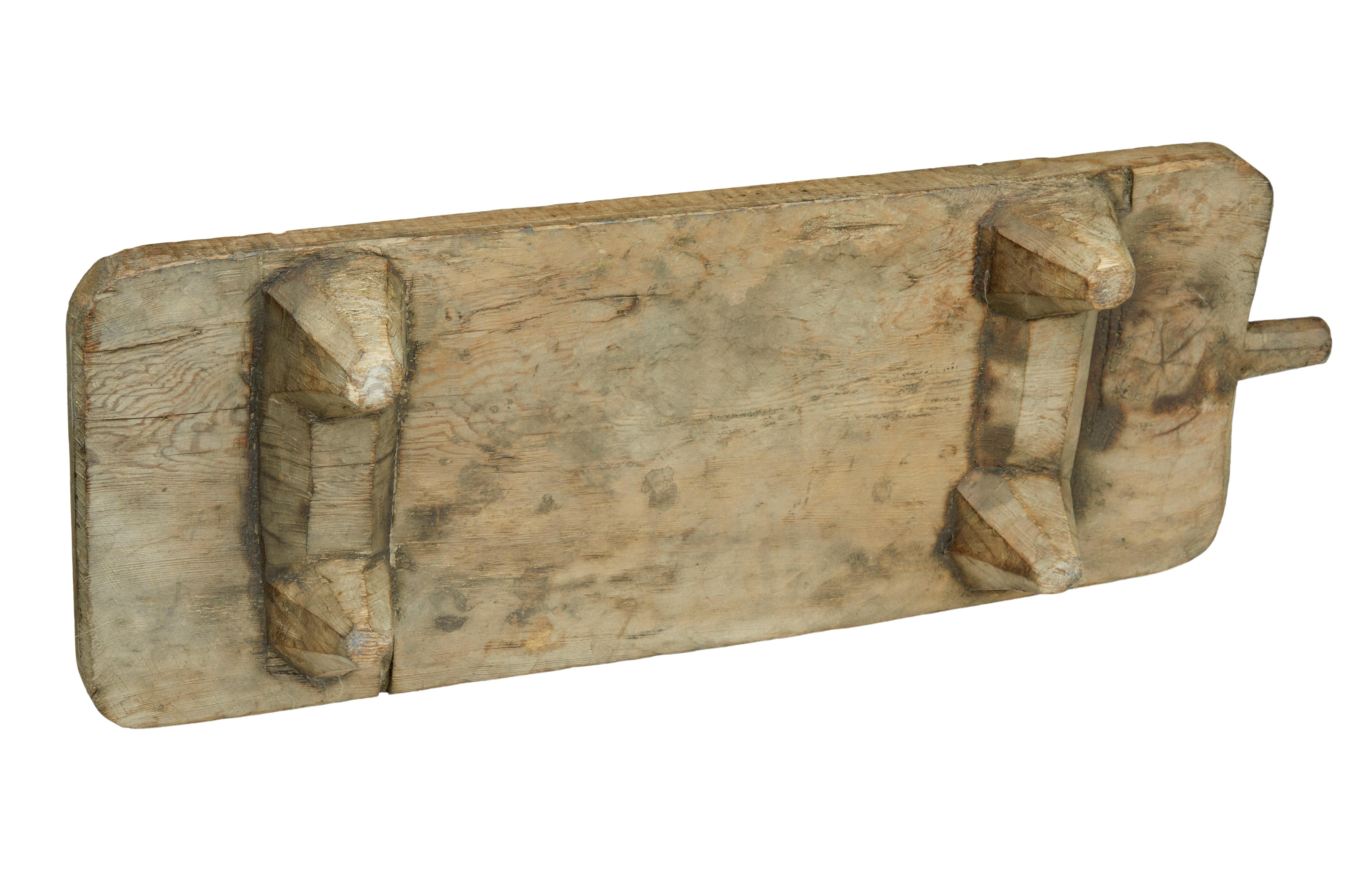 Unusual Scandinavian solid pine chopping / bread board, circa 1880.

Substantial piece of pine with the feet hand carved from the solid. Top has taken on a desirable patina with 1 handle at the end.

Ideal for a display piece or table server or