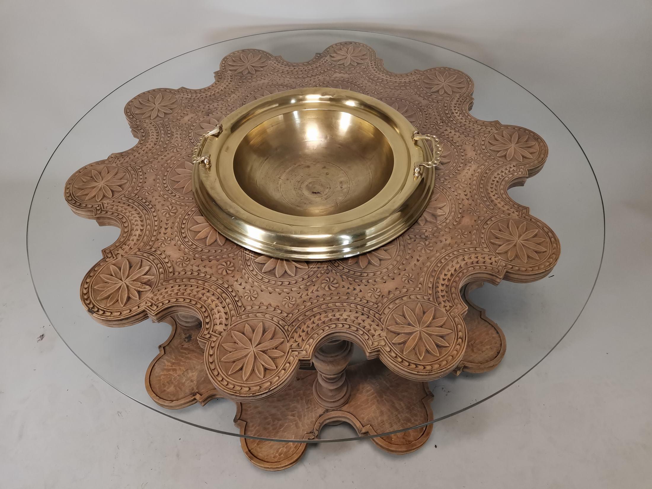 19th century solid wood coffee table.
Above it has a glass back
In the centre it has a brass pot for flowers. 
Measures: 50 cm high and 110 cm in diameter
Good condition.