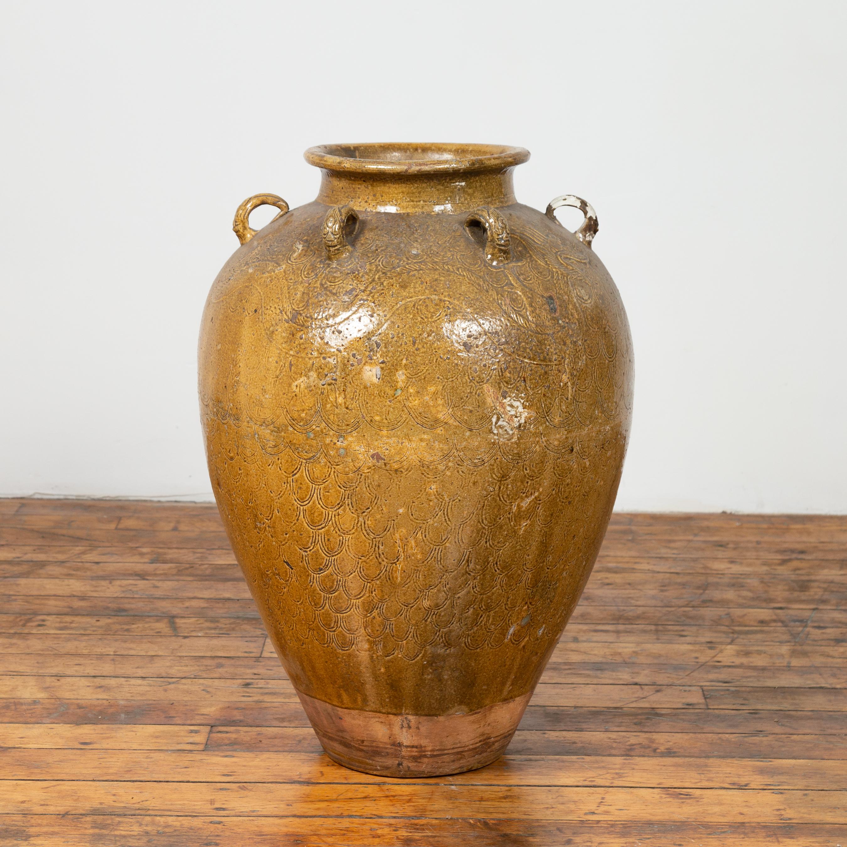 A South Eastern 19th century Martaban water jar with dragon motifs and petite handles. Used as a storage vessel to ship food and water, this Martaban jar charms our eyes with its nice proportions and lovely color. Originating from the city of