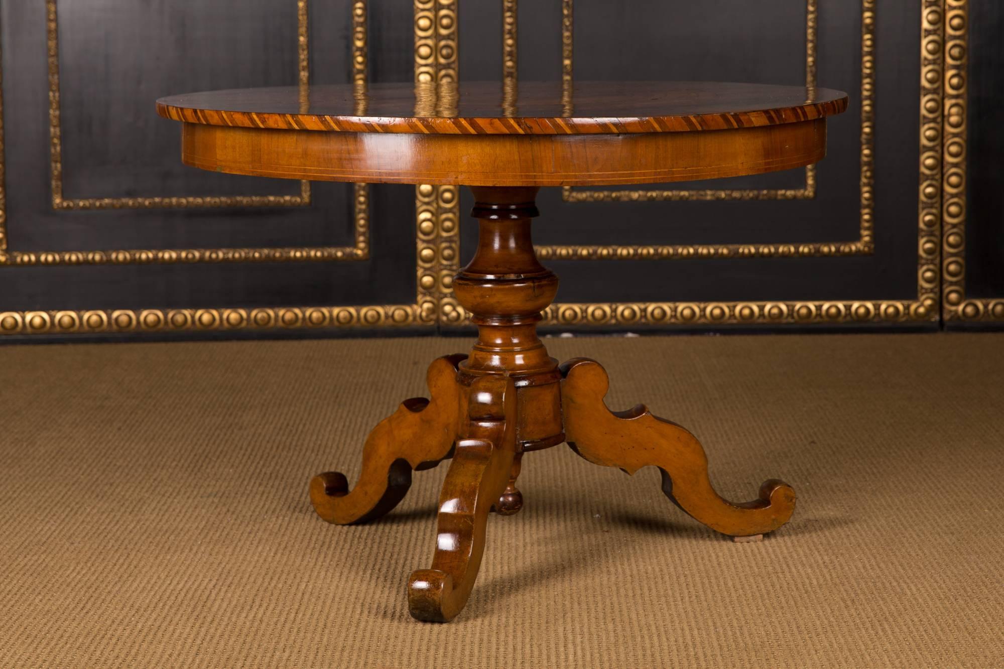 Walnut root on softwood. Turned column-shaft below it, three volute-curved legs. Straight cheeks for round tabletop with a fantastic inlay work
A Classic form of the Biedermeier period.

Excellent warm patina aged over decades. Age-related use