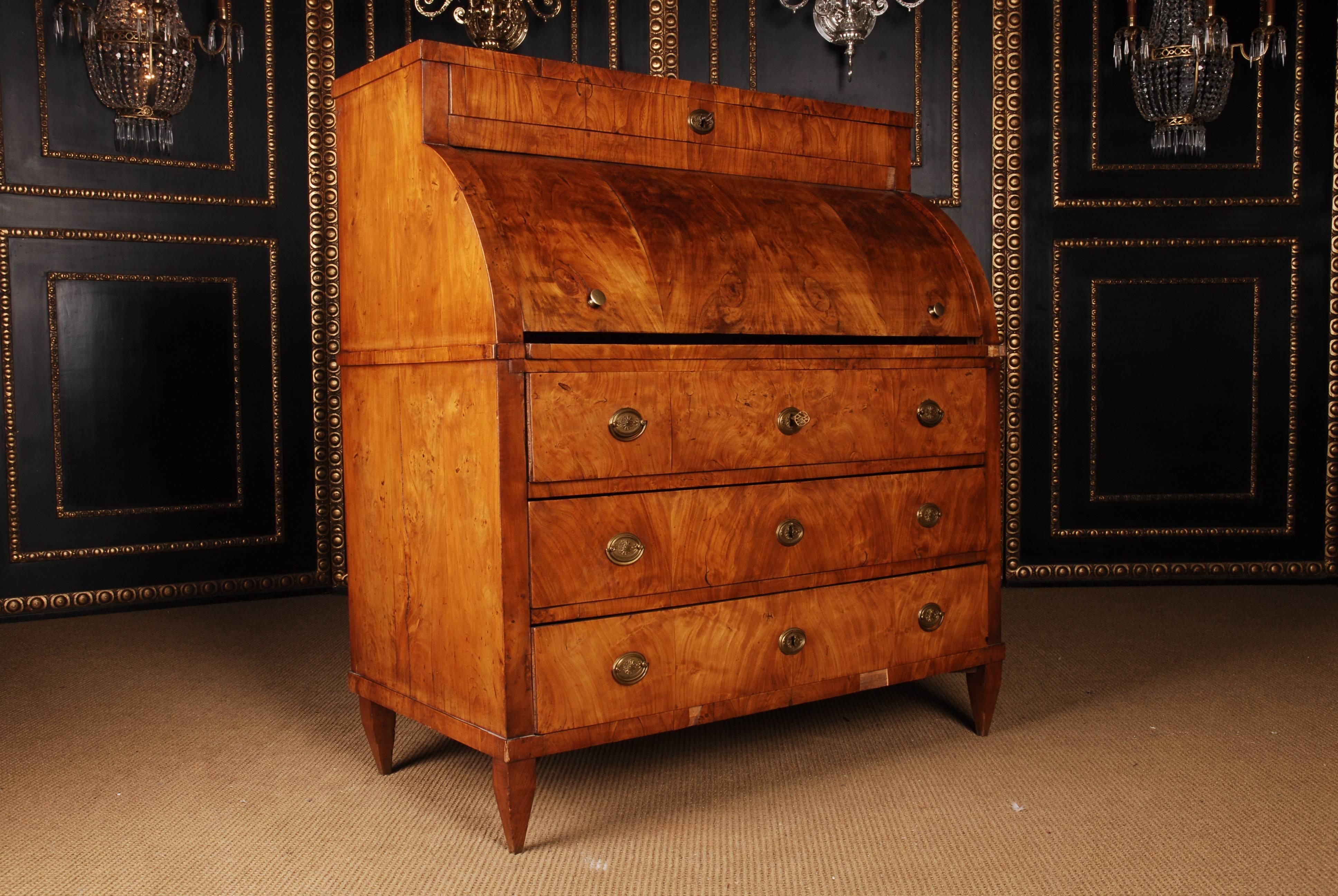 2 mm thick cherry veneer on solid pine. High-corpuscular body. Bottom front view three drawers, overwriting cylinder with pull-out writing surface. Behind office division. Top drawer back.

A good historical condition with a beautiful warm patina.