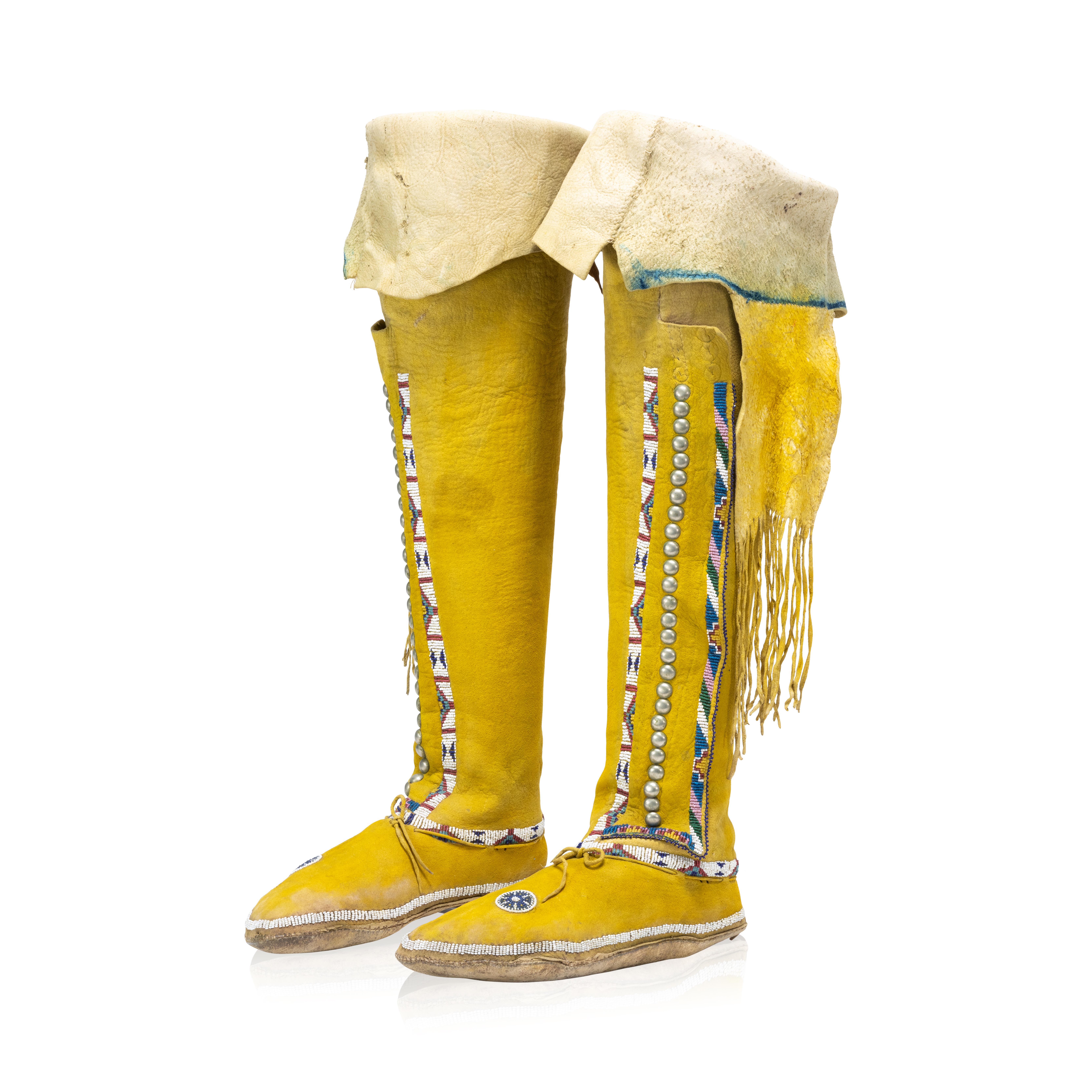 Southern plains Hightop Moccasins
Item Number: AG2312

Exceptional Kiowa/Comanche hightop moccasins dyed with yellow ochre. Adorned with a single beaded band above the sole, the leggings with two beaded bands down the seam and across the cuff,