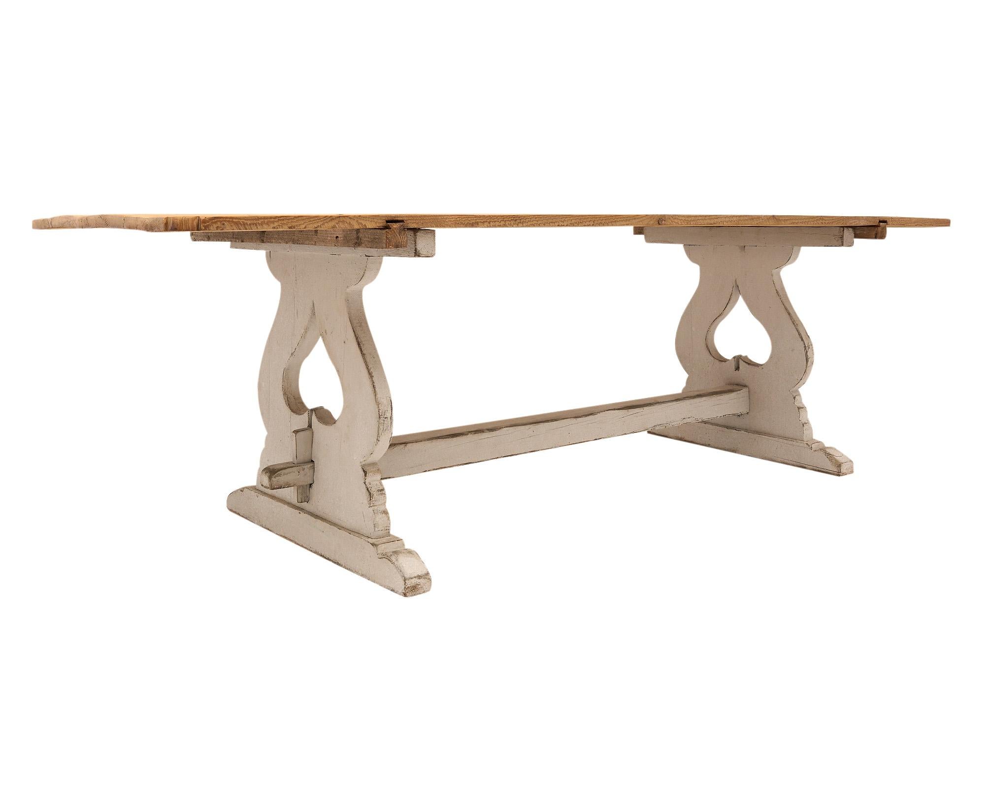 Farm table from Tuscany (Italy )with a four plank top and a painted wooden base with two Spade adorned pedestals and a stretcher. The hand carved detail of the base features the spade shape.
