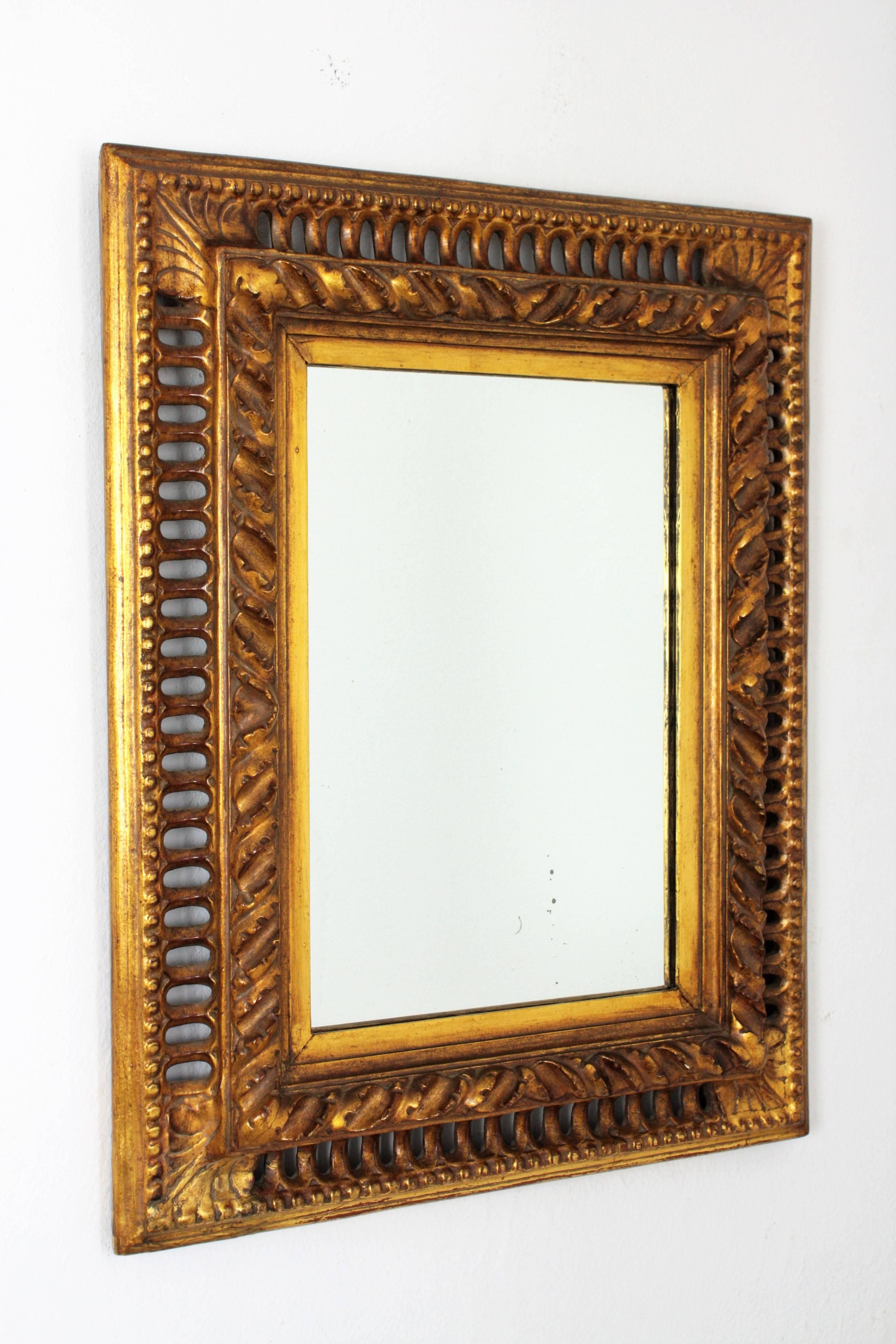 Exquisite hand carved Baroque style gold leaf giltwood mirror with reticulated frame, Spain, circa 1880.
The frame has a very beautiful hand carved work with a spiraling foliate border surrounding the glass mirror plate and coved reticulated outer