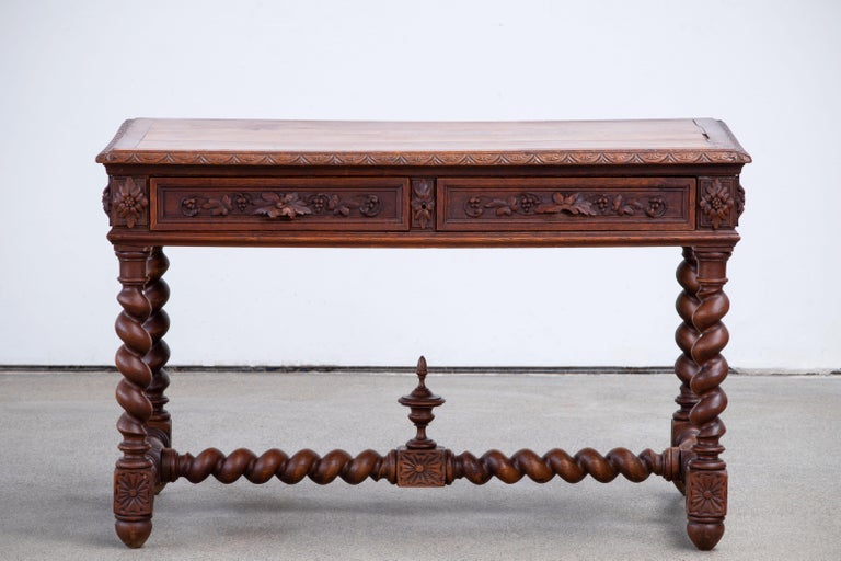 19th Century Spanish antique oak desk, writting table with two drawers.
This elegant console was crafted in Spain, circa 1900, it features hand-carved details and turned legs. 
The narrow console is in good condition with a rich patinated