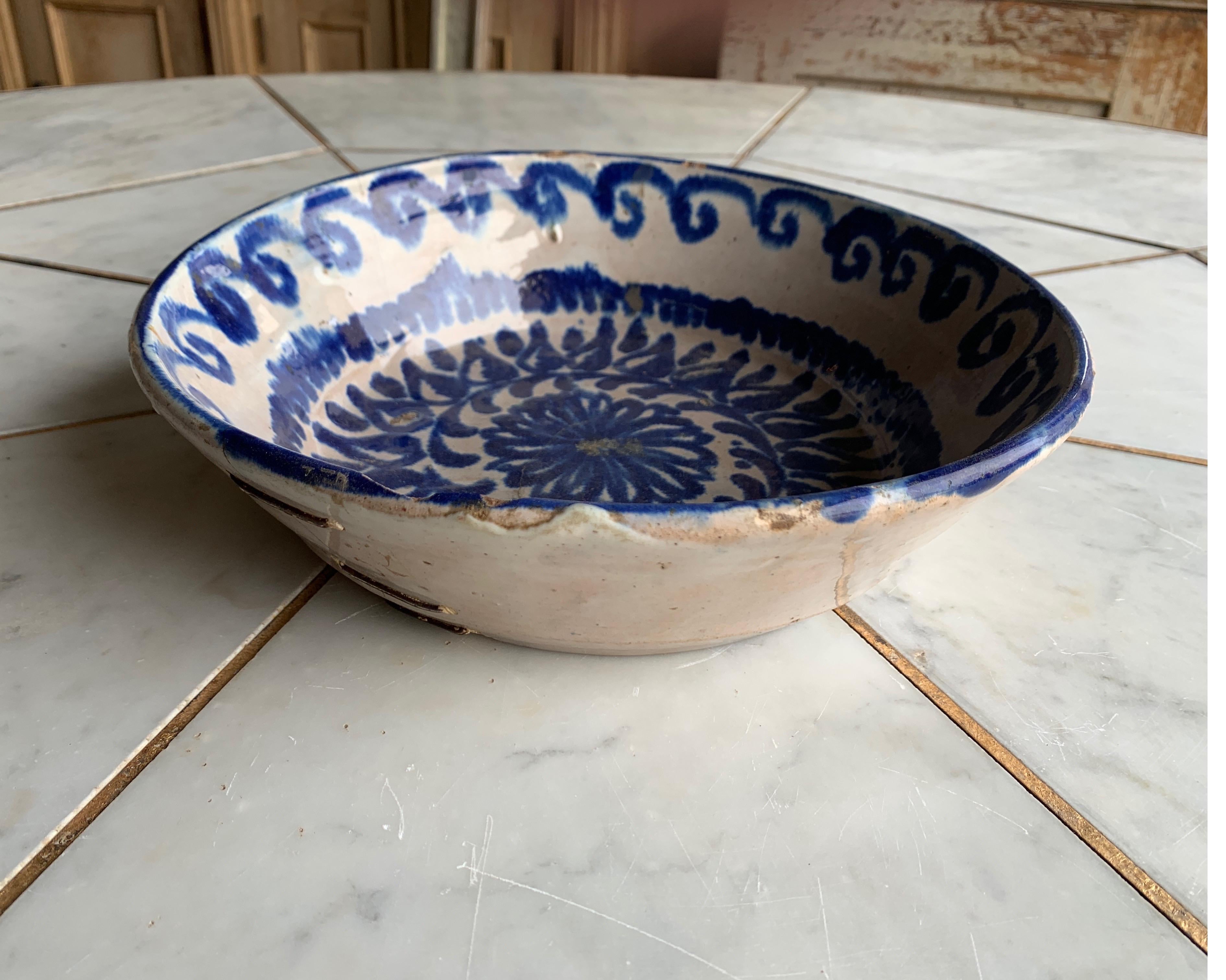 This is a bowl from Spain originating from the Catalonia region. It has old staples to hold hairline crack from splitting further which was common throughout Spain and Europe to mend cracks. It adds tons of character and great for a decorative