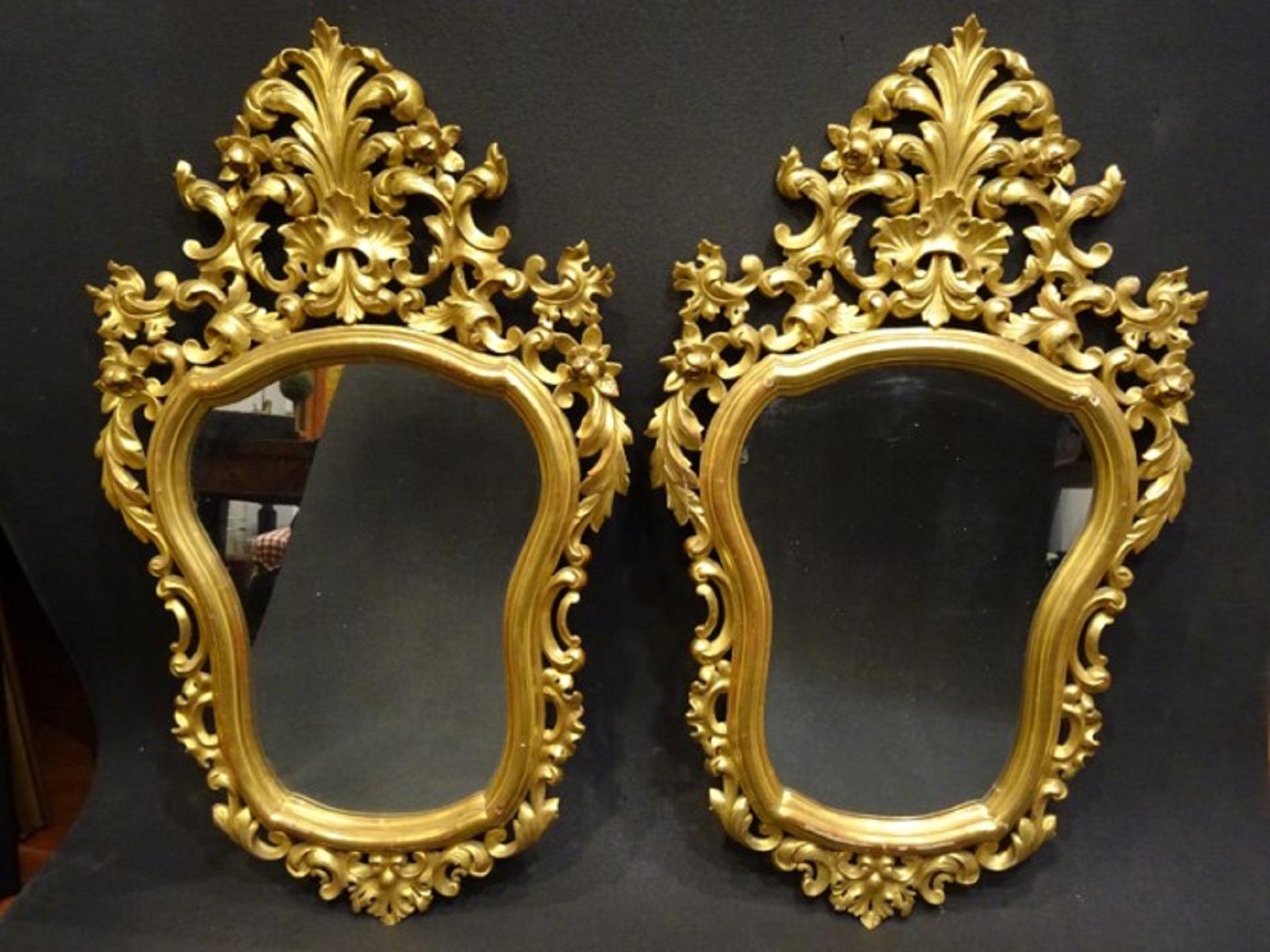 Stunning couple of 19th century Spanish carved and gilded wood wall mirrors.
They have a floral cut and rolls, the wood is gilded with gold of 18-karat and burnished with agata stone.
They look gorgeous!!!!!! They are a very sought after pieces,